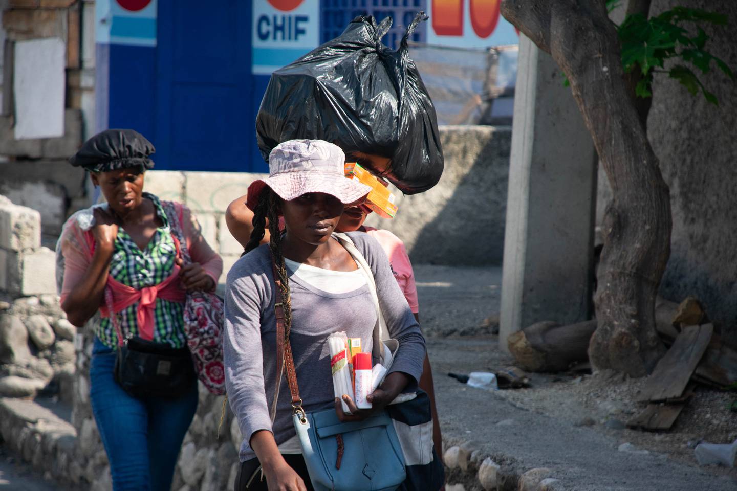 Los vendedores ambulantes abandonan el área después de escuchar disparos entre pandillas y policías, en Puerto Príncipe.