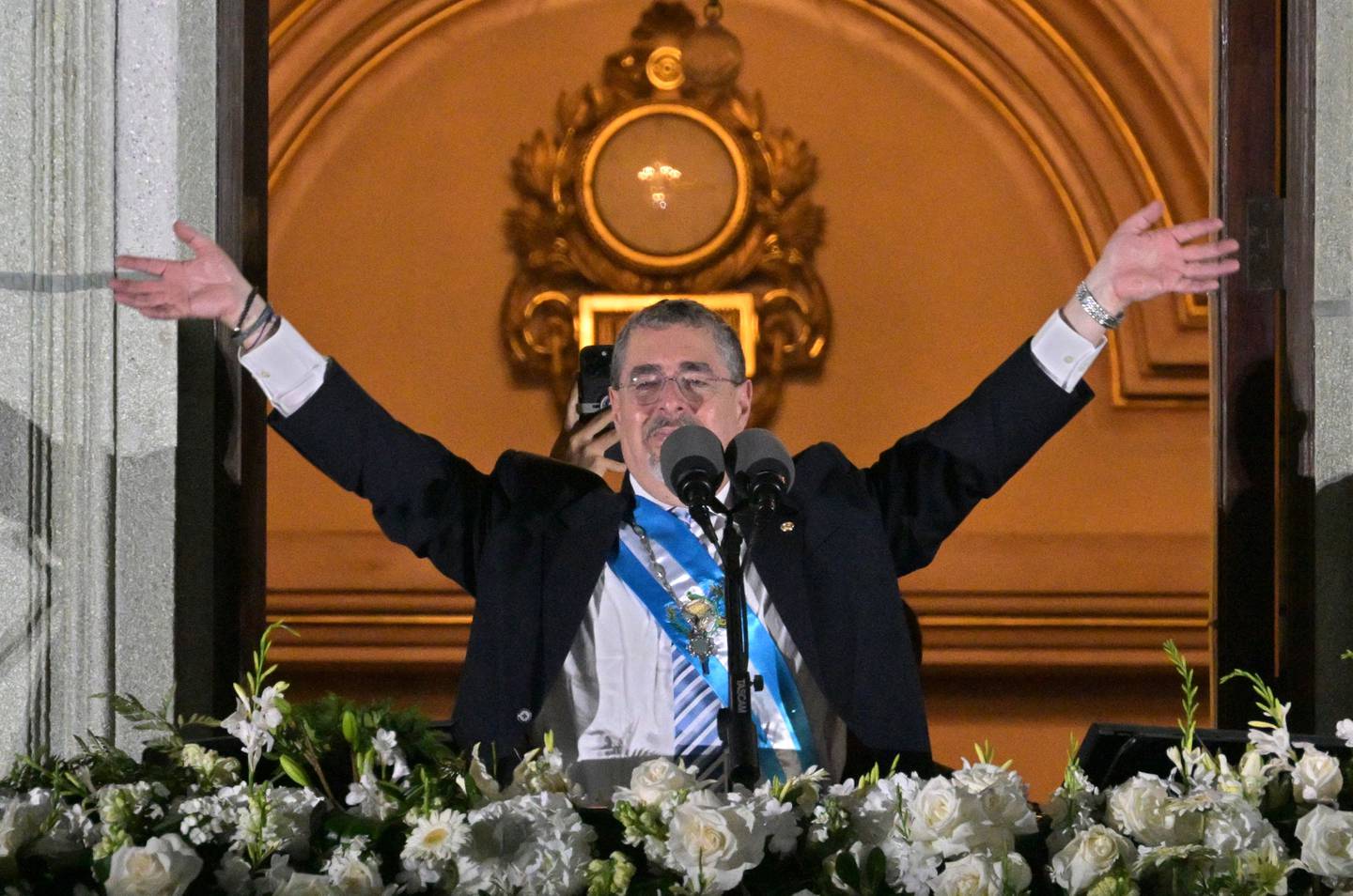 El nuevo presidente de Guatemala, Bernardo Arévalo, hace gestos a sus partidarios desde un balcón del Palacio Nacional de Cultura en la Ciudad de Guatemala, después de su ceremonia de toma de posesión, a primera hora de este lunes.