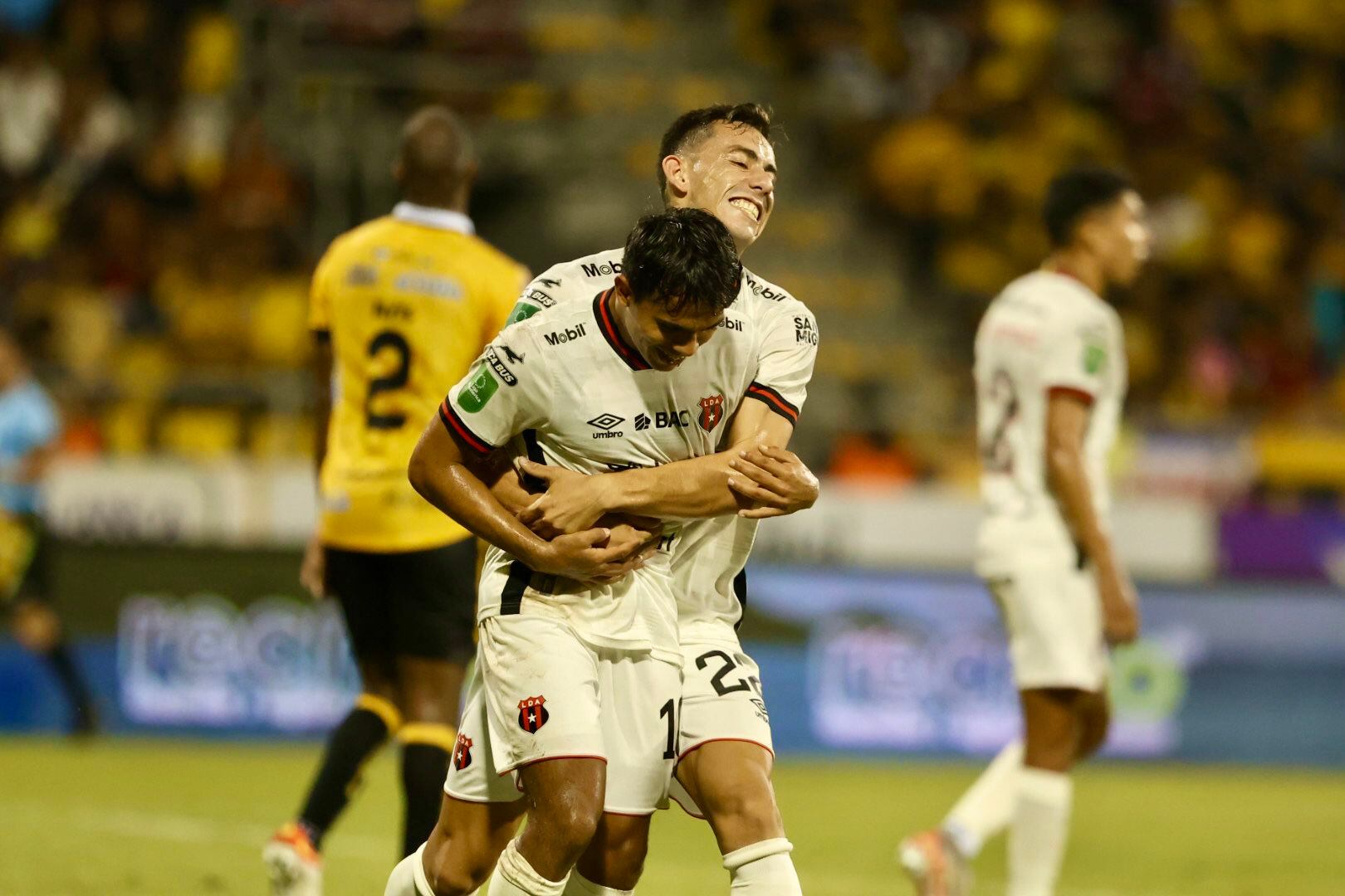 Kevin Cabezas abraza a Aarón Suárez, luego de que convirtió el tercer gol en el partido contra Liberia.