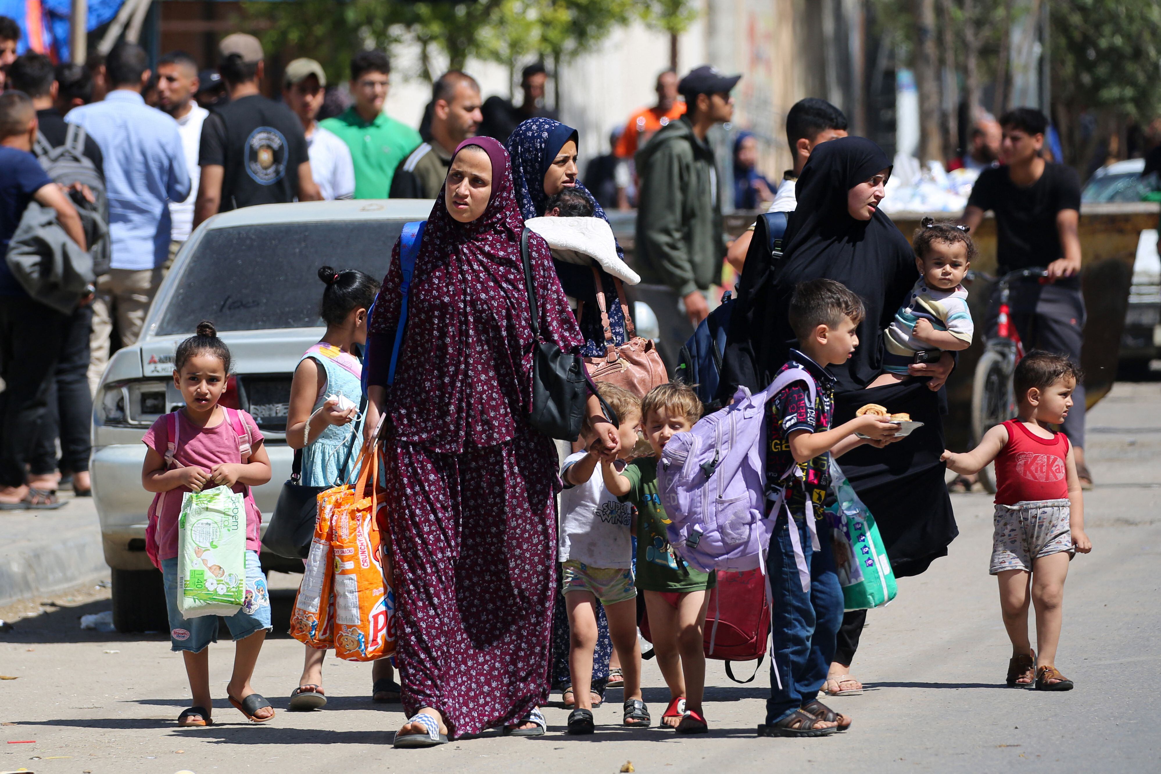 Mujeres y niños palestinos huyen de Rafah, en el sur de la Franja de Gaza, con algunas pertenencias en medio del conflicto en curso entre Israel y el movimiento militante Hamás. Foto de AFP
