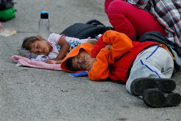 Niños, que forman parte de la caravana centroamericana que espera llegar a la frontera con Estados Unidos, duermen en la carretera, en Donaji, estado de Oaxaca, México, el viernes 2 de noviembre de 2018. AP