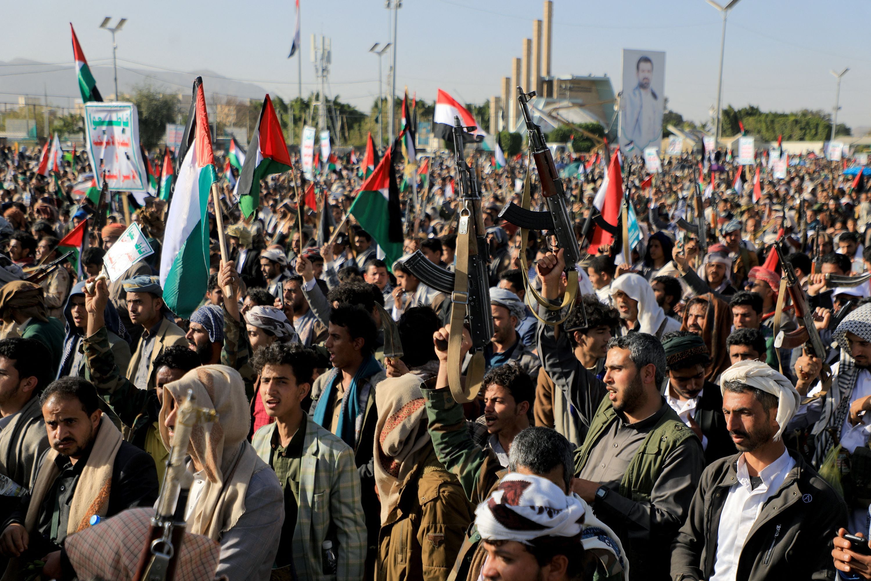 Combatientes hutíes sostienen banderas palestinas y muestran sus armas durante una protesta tras los ataques de las fuerzas estadounidenses y británicas.