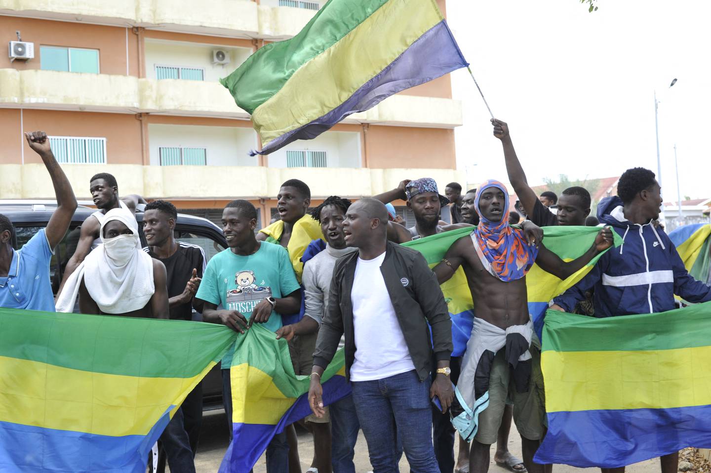 Habitantes ondeando banderas nacionales de Gabón celebran en Libreville este miércoles luego de que oficiales militares gaboneses anunciaran en televisión el "fin del régimen actual", rechazando los resultados electorales que habían concedido otro mandato al  presidente Ali Bongo.