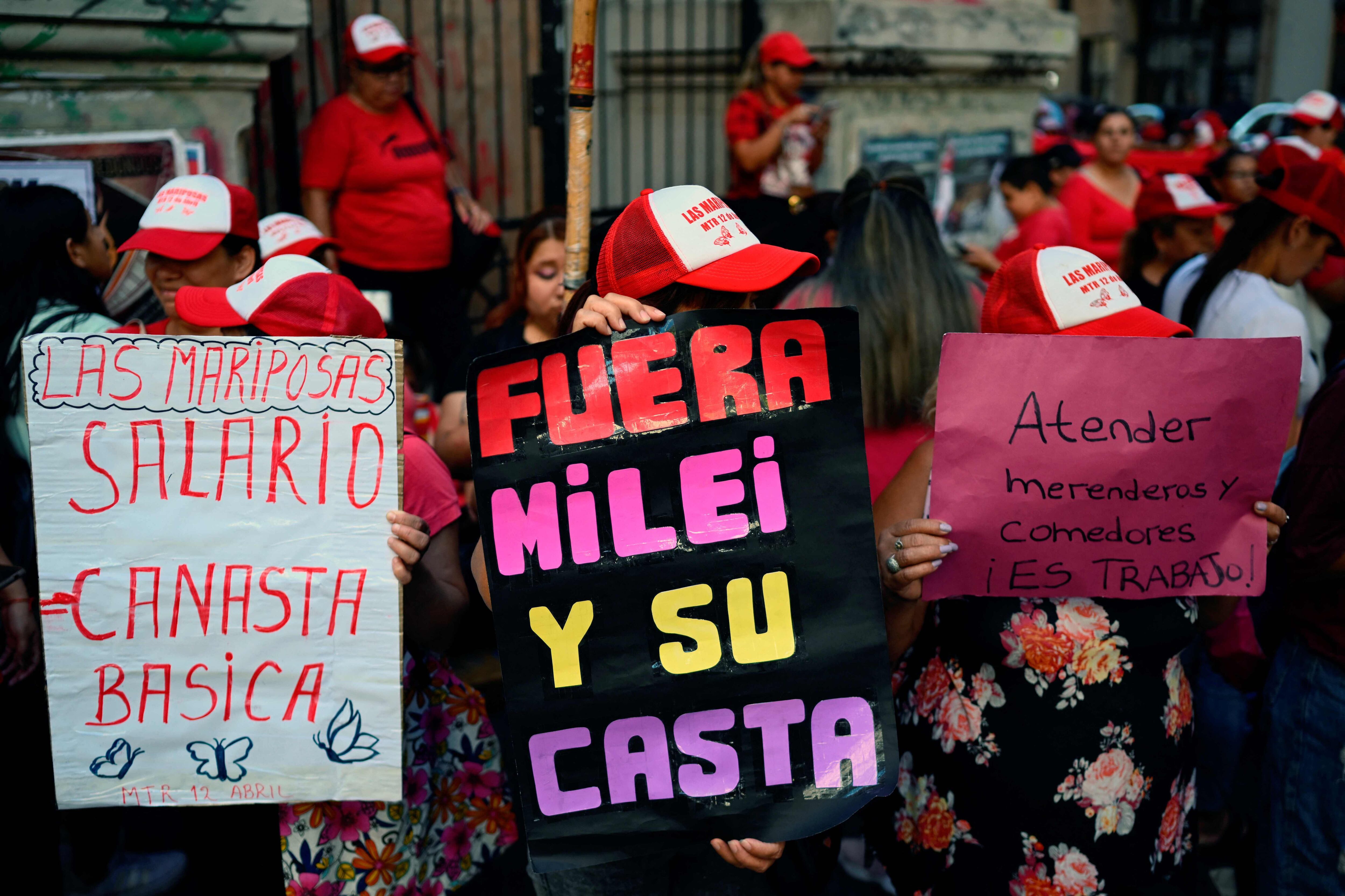 Mujeres sostienen carteles contra las políticas del gobierno del presidente Javier Milei mientras protestan durante una marcha para conmemorar el Día Internacional de la Mujer. 