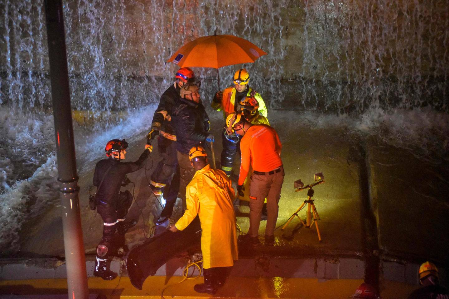 Los rescatistas buscan personas atrapadas debajo de un muro que se derrumbó sobre varios vehículos tras las fuertes lluvias en la avenida 27 de febrero de Santo Domingo el pasado 18 de noviembre de 2023. (Foto de Félix León/AFP)