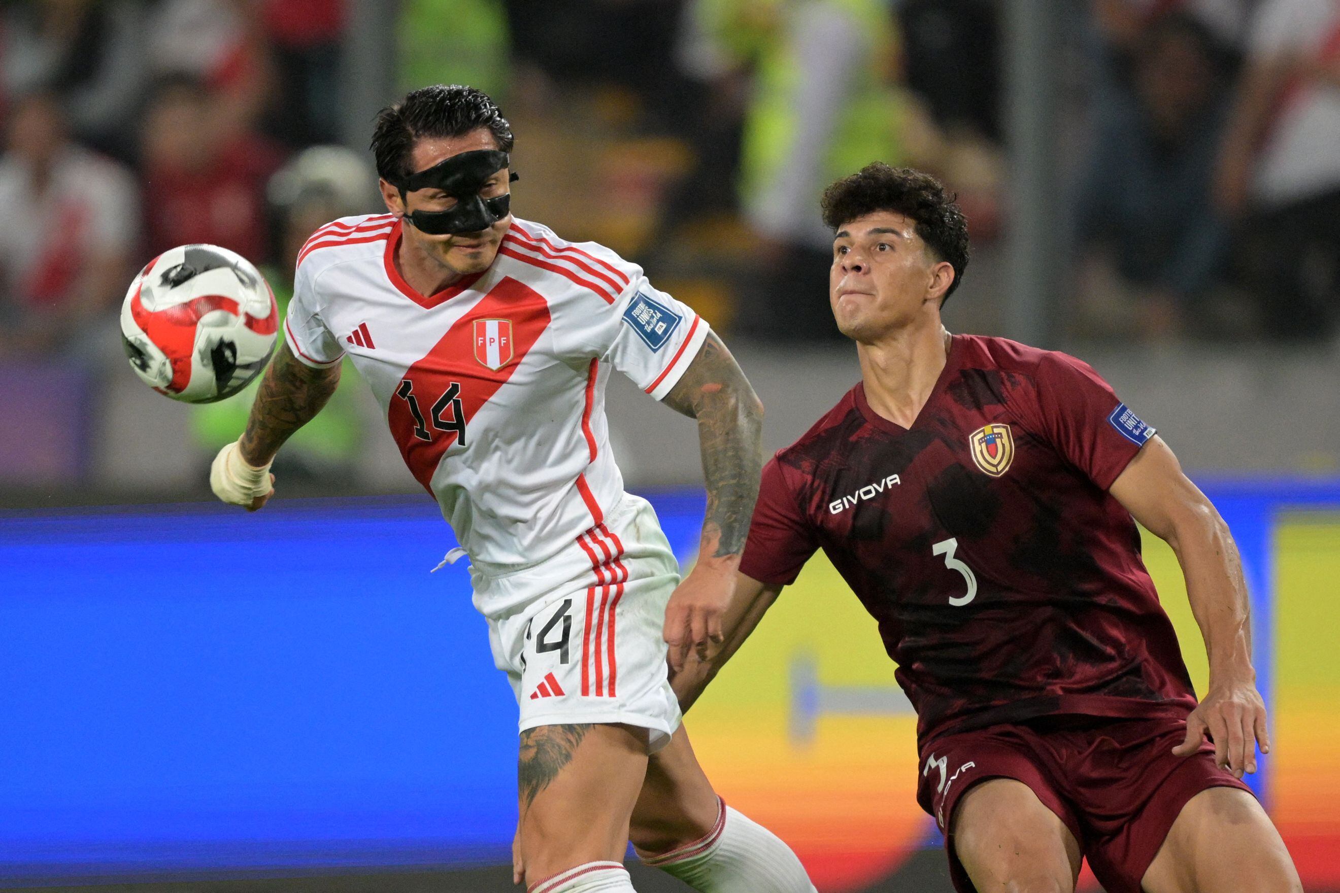 El delantero peruano Gianluca Lapadula (i) lucha por el balón con el defensor venezolano Yordan Osorio durante el partido de fútbol de clasificación sudamericano para la Copa Mundial de la FIFA 2026 entre Perú y Venezuela en el Estadio Nacional de Lima.