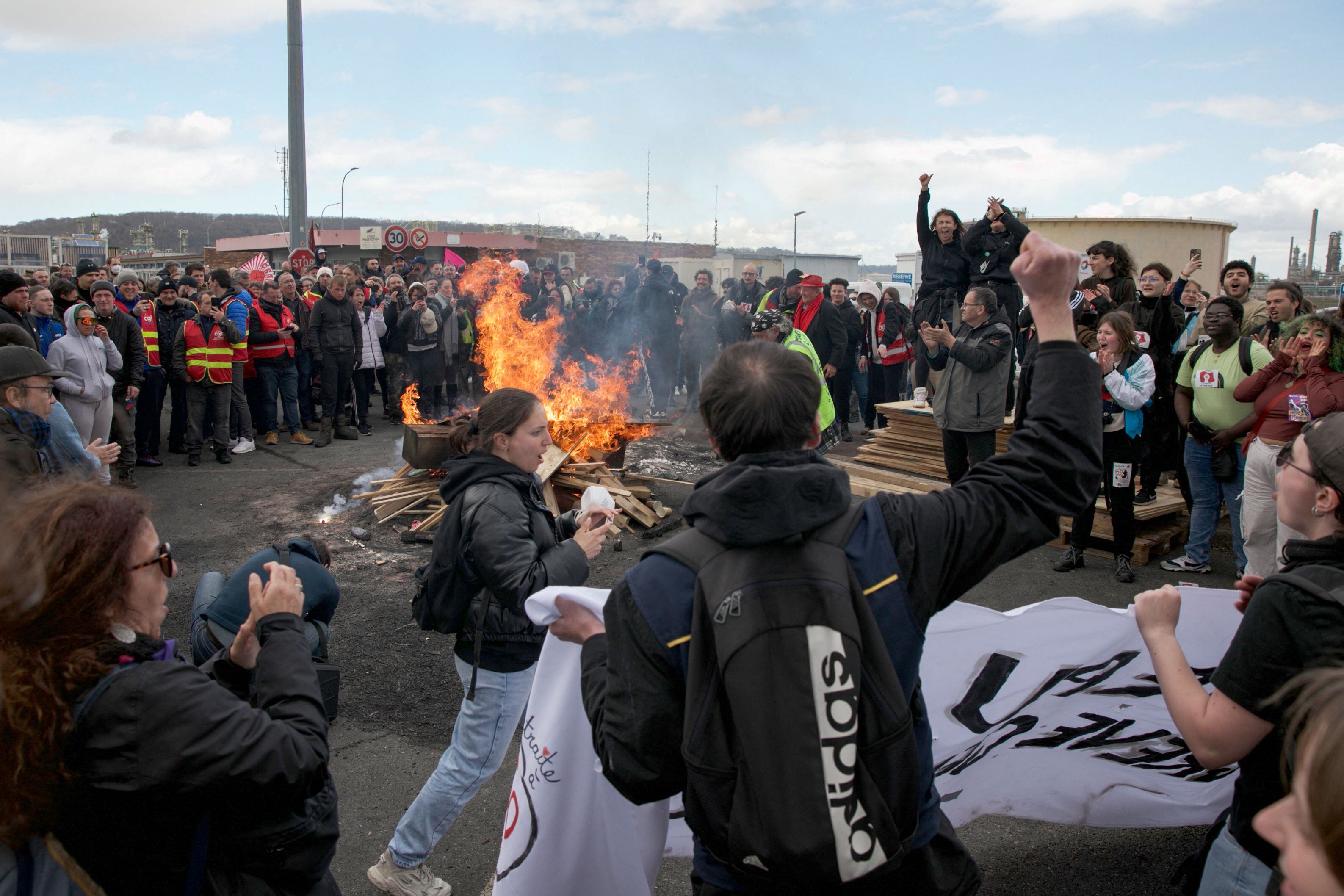 Los manifestantes reaccionan y se reúnen alrededor de una fogata durante una manifestación de Totalenergies que golpea a los empleados frente a la refinería de Gronfreville-l'Orcher, en el norte de Francia.