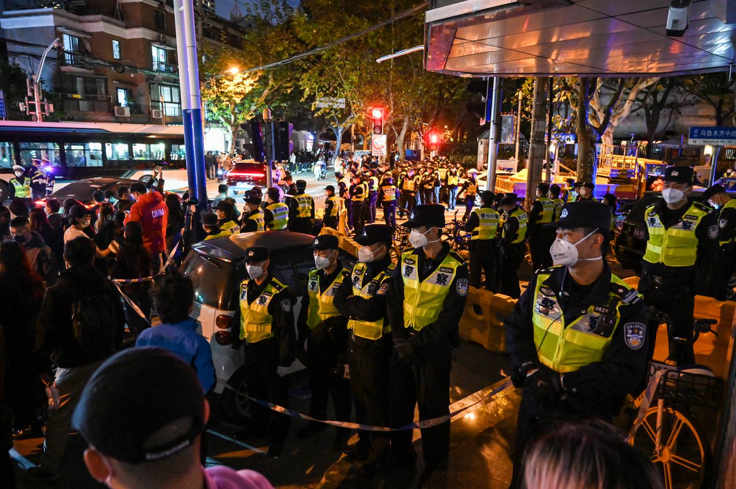 Agentes de policía bloquean la calle Wulumuqi, llamada así por Urumqi en mandarín, en Shanghai el 27 de noviembre de 2022, en el área donde la noche anterior tuvieron lugar protestas contra la política cero-Covid de China luego de un incendio mortal.