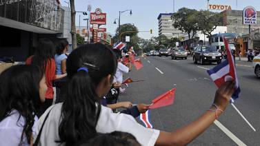 Escolares saludan al presidente Xi Jinping en su paso por paseo Colón