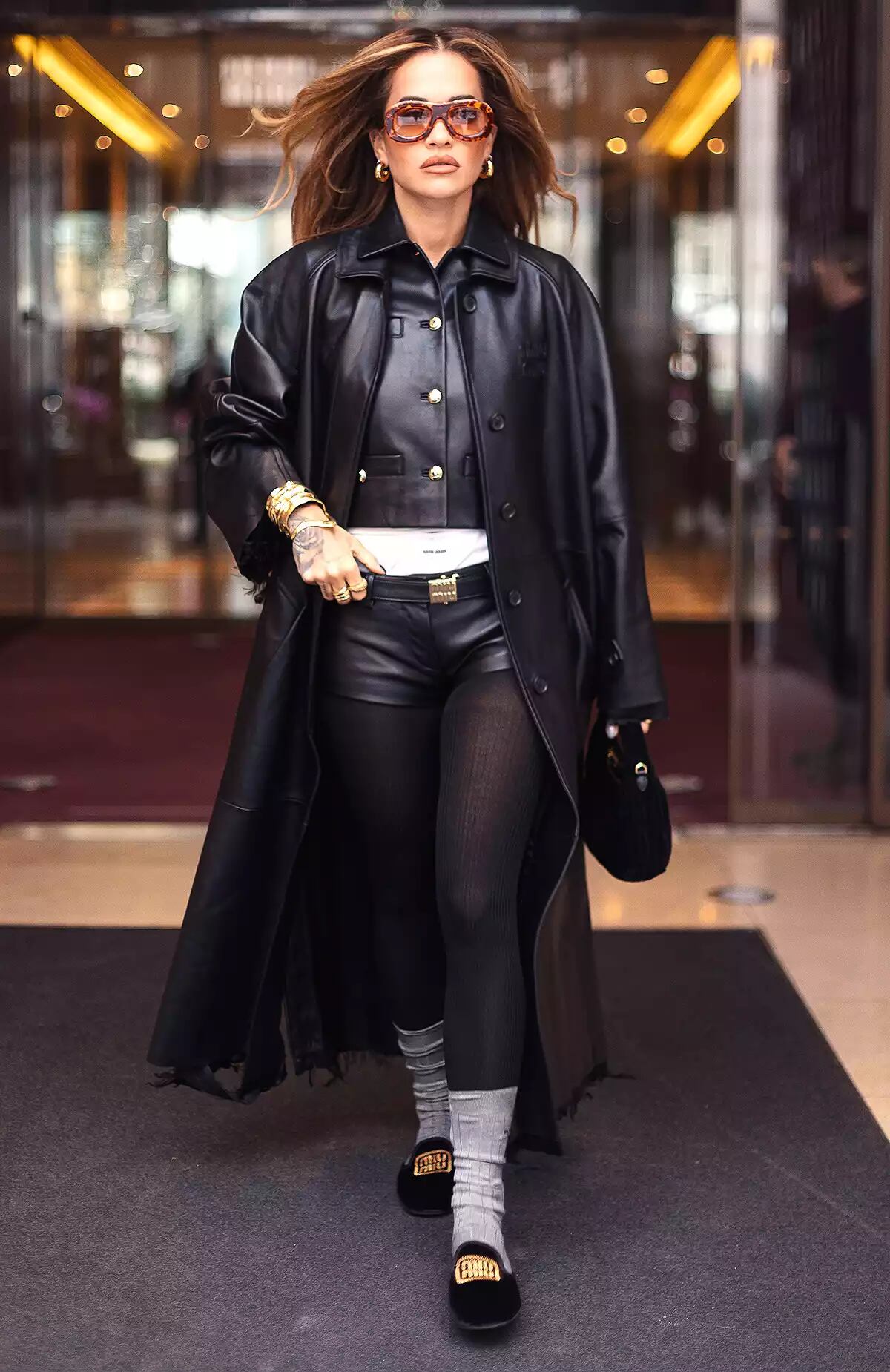 La cantante Rita Ora combinó sus pantalones con una gabardina, una blusa abotonada y mocasines.