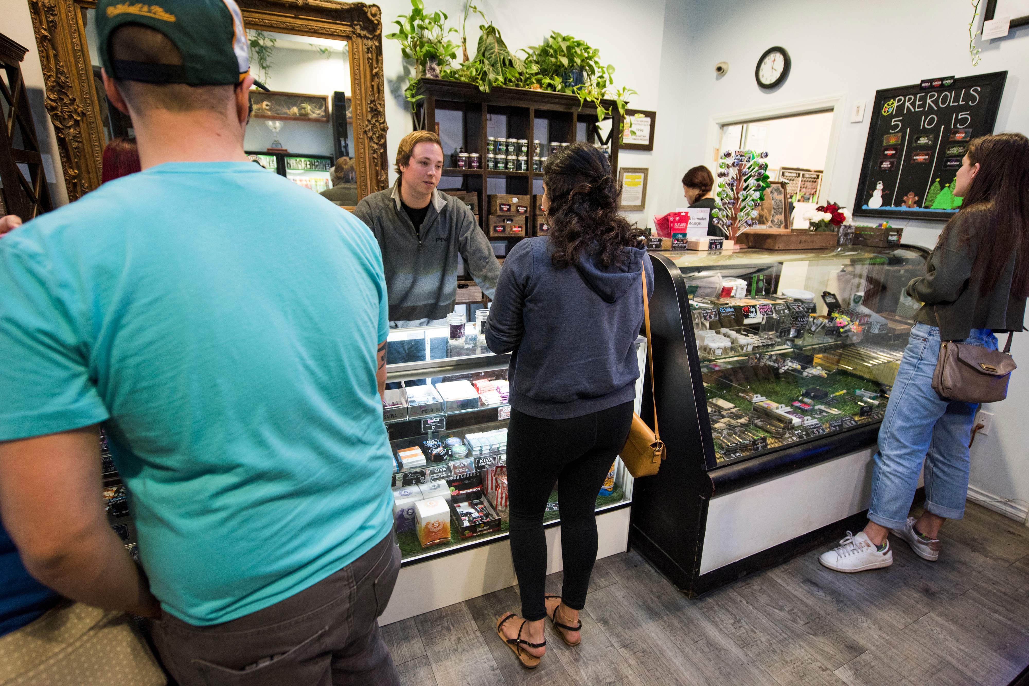 Un vendedor ayuda a los clientes mientras otros esperan su turno en el dispensario de marihuana medicinal en el área de San Fernando Valley en Los Ángeles, California.