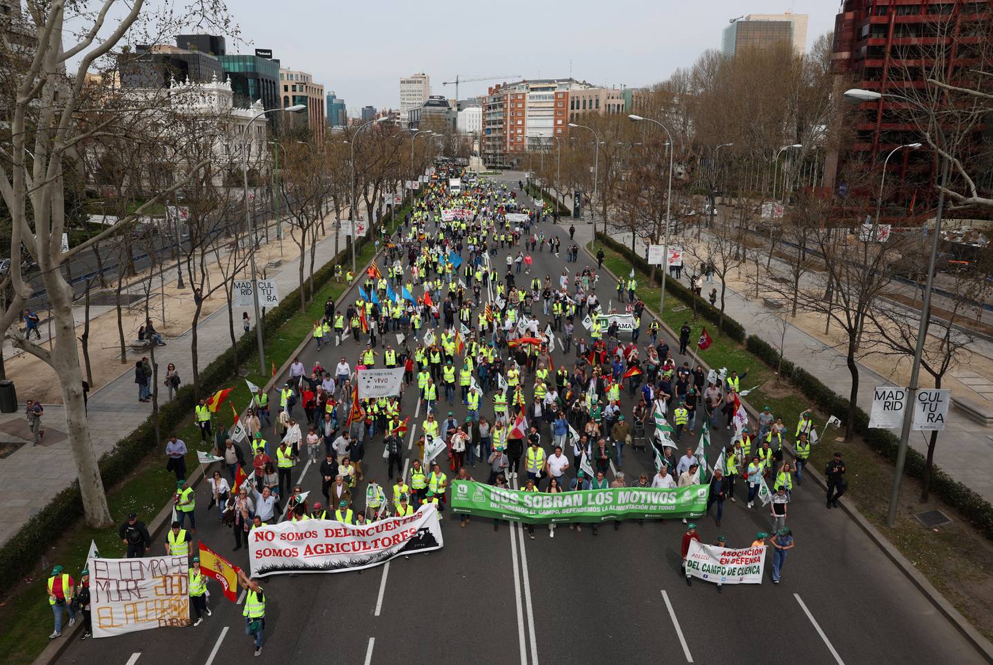 Los agricultores sostienen pancartas que dicen 'No somos hooligans, somos agricultores', 'el sector agrícola está muriendo' durante una protesta organizada por el sindicato Unión de Uniones, en el centro de Madrid.