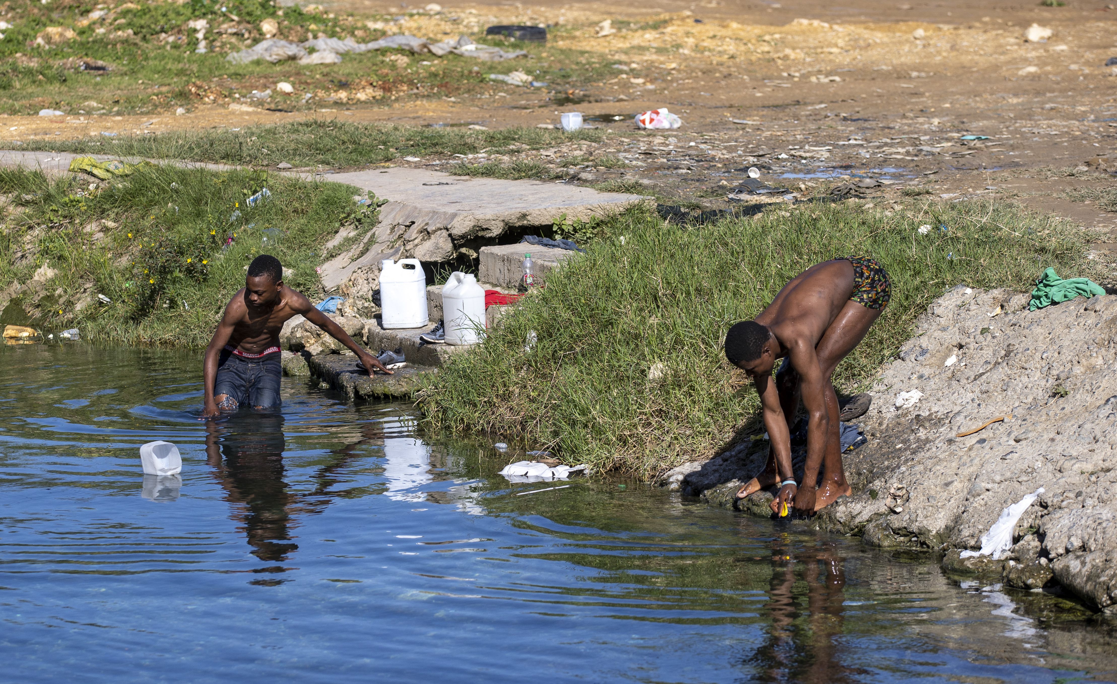 Hombres se bañan en una piscina de agua de manantial natural que se confirmó que estaba contaminada con la bacteria del cólera en La Zurza, un sector de Santo Domingo junto al río Isabela, el 9 de febrero de 2023.