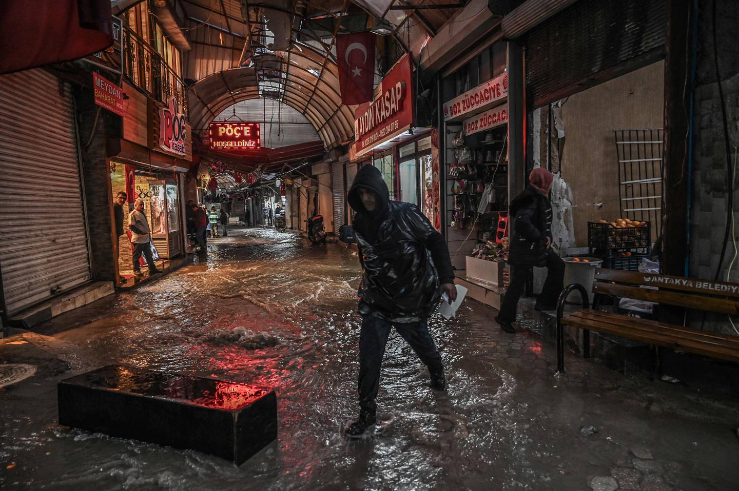 La gente intenta evitar las inundaciones en el bazar de Uzuncarsi después de las fuertes lluvias, once meses después de que un terremoto de magnitud 7,8 y sus réplicas arrasaran con amplias zonas del sudeste montañoso de Turquía, en Antakya. El doble terremoto, en medio de La noche del 6 de febrero de 2023 mató a más de 50.000 personas y arrasó franjas de ciudades enteras en todo el sureste de Turquía. Ningún lugar se vio más afectado que Antakya, una cuna de civilizaciones rodeada de montañas cerca de la frontera con Siria, donde se perdieron casi el 90 por ciento de los edificios. (Foto de Ozan KOSE / AFP)