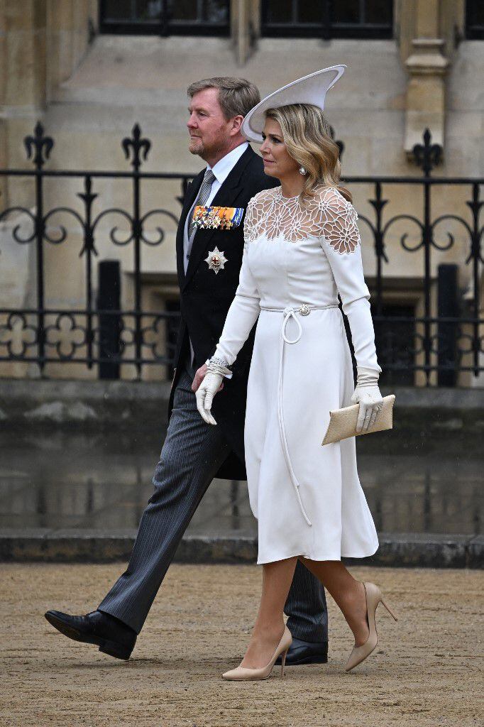 La reina Máxima de los Países Bajos optó por un vestido blanco con detalle en la parte superior. El atuendo adornó la cintura con un sutil cinturón y combinó los accesorios menos los zapatos, que eran de una tonalidad más cálida que el resto del atuendo. En la cabeza llevaba un híbrido entre pamela y tocado.