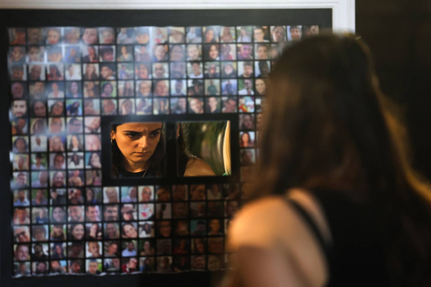 Una mujer mira retratos de rehenes israelíes tomados por militantes palestinos en el ataque del 7 de octubre durante una manifestación que pedía su liberación en Tel Aviv.