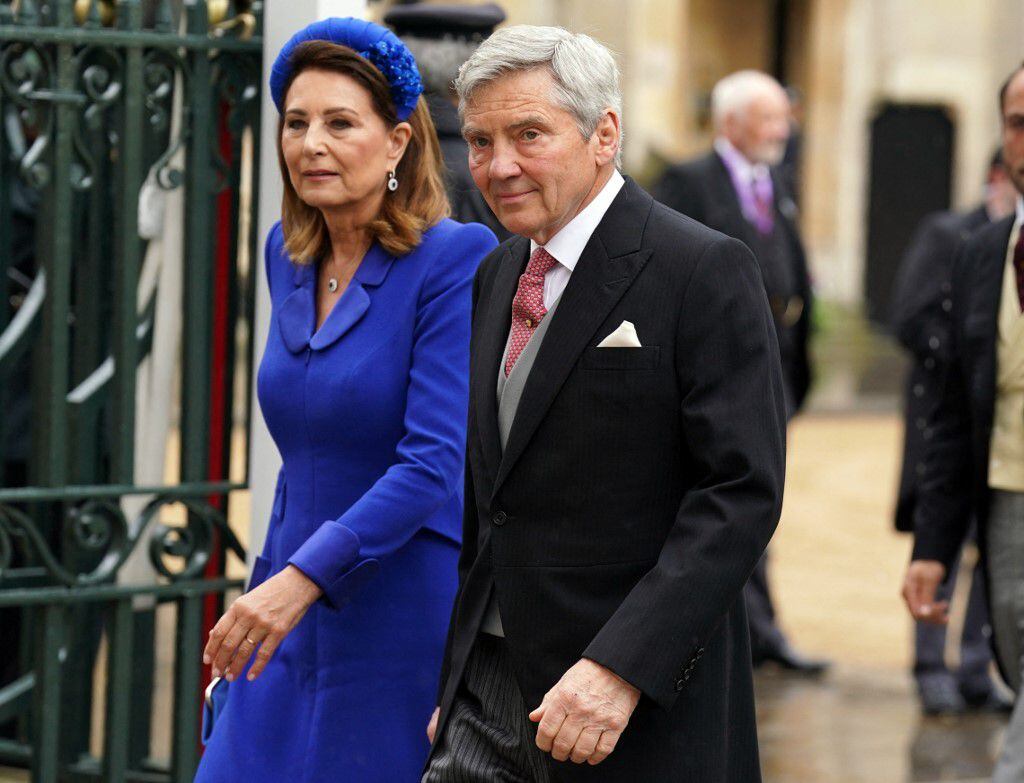 Los padres de la princesa Kate no podían faltar. Carole Middleton eligió un vestido azul rey que combinó con una elegante diadema y cartera del mismo color. Curiosamente, sus accesorios lucían muy similares al estilo del anillo de compromiso de la princesa Diana, que ahora pertenece a Kate. 