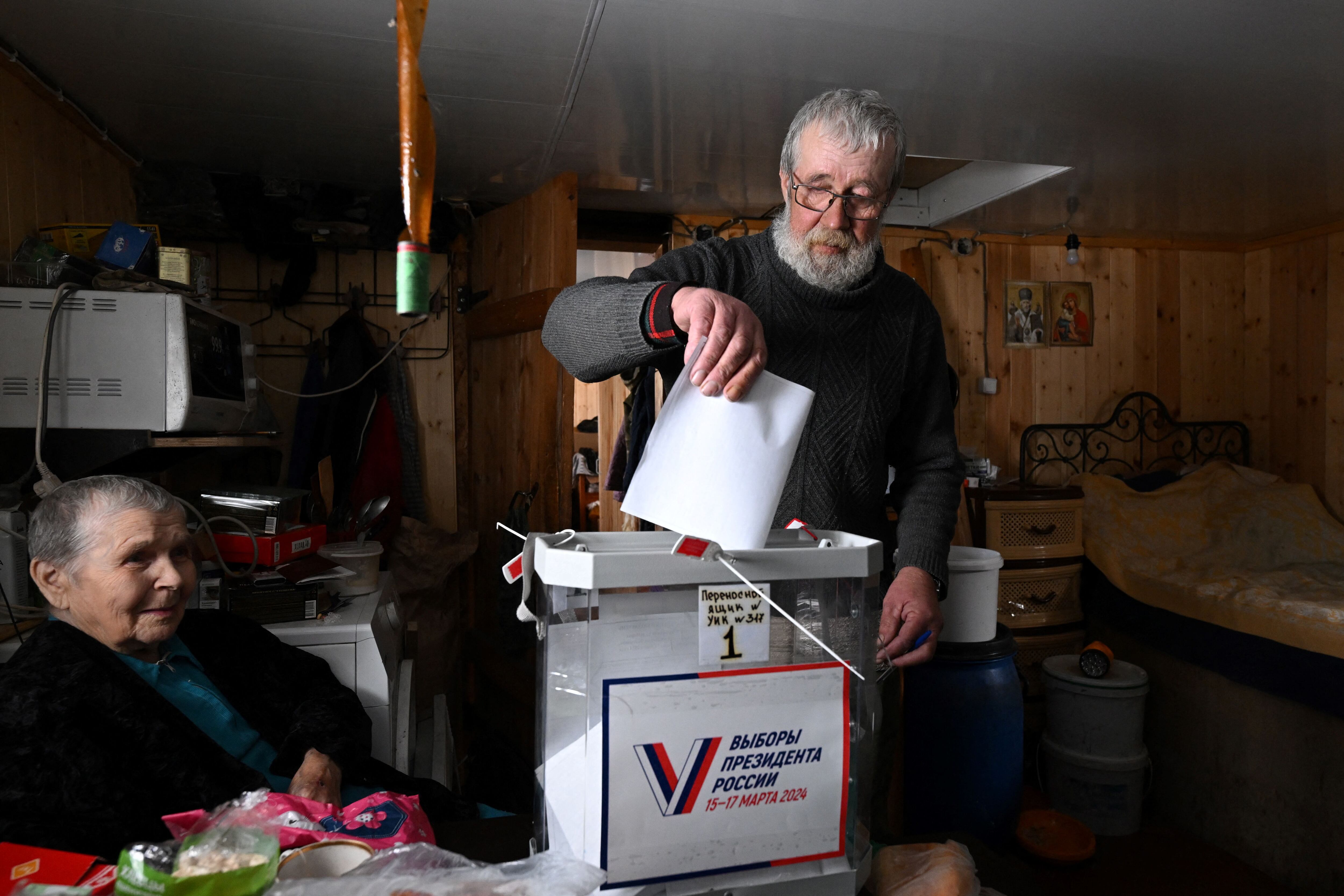 Un hombre deposita su voto en su casa durante la votación anticipada para las elecciones presidenciales de Rusia en la aldea de Longasy, República de Karelia.
