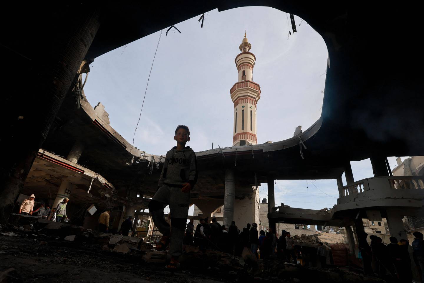 La gente inspecciona los daños entre los escombros de una mezquita tras el bombardeo israelí, en Rafah, en el sur de la Franja de Gaza, el 12 de febrero de 2024, en medio de batallas en curso entre Israel y el grupo militante palestino Hamas. (Foto de MOHAMMED ABED / AFP)