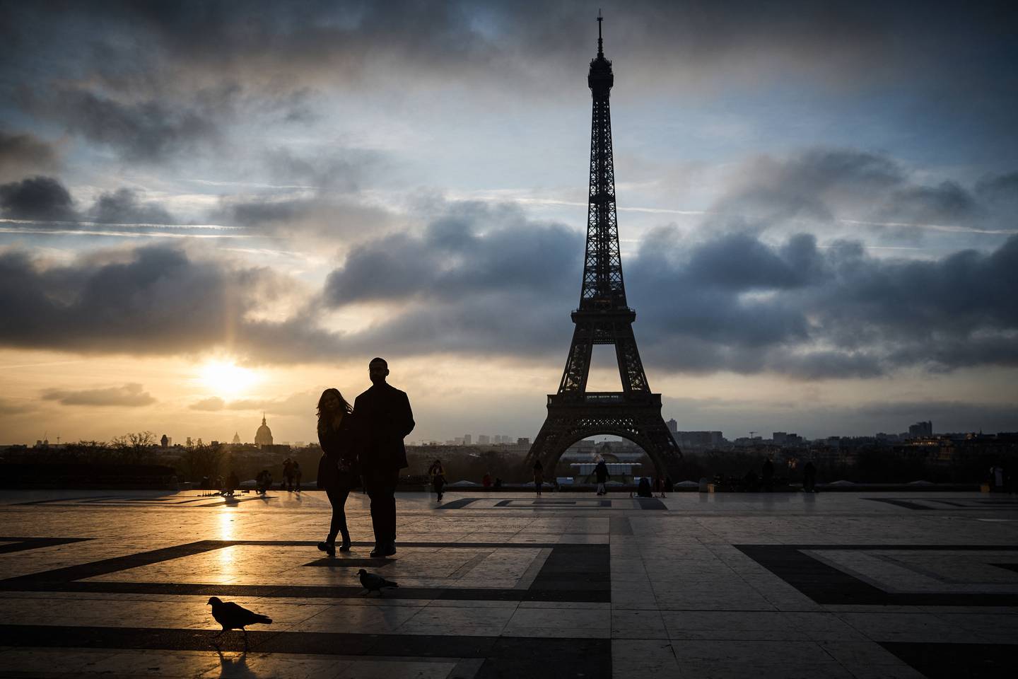 Una pareja de turistas observa de lejos la Torre Eiffel. No lograron ingresar a la atracción parisina porque se encuentra cerrada.