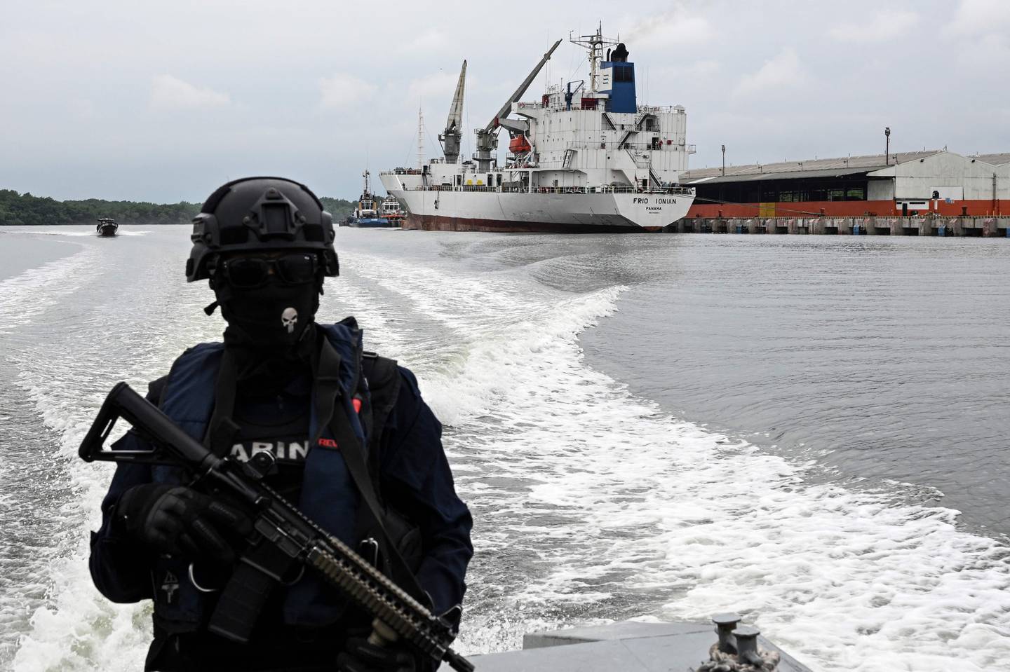 Un miembro del Comando de Guardacostas (Coguar) de la Armada del Ecuador navega en una patrulla a lo largo de canales afluentes del río Guayas junto a terminales portuarias mientras participa en una patrulla antinarcóticos en Guayaquil.