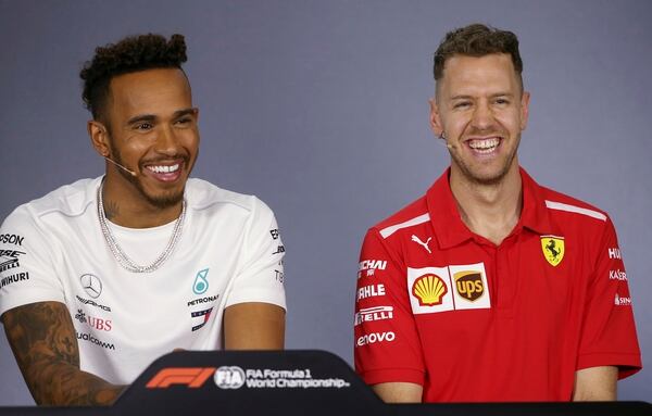 El británico Lewis Hamilton y el alemán Sebastian Vettel durante una conferencia de prensa que ofrecieron en Melbourne, Australia, donde este domingo comienza la temporada de Fórmula 1. (AP Photo/Rick Rycroft)