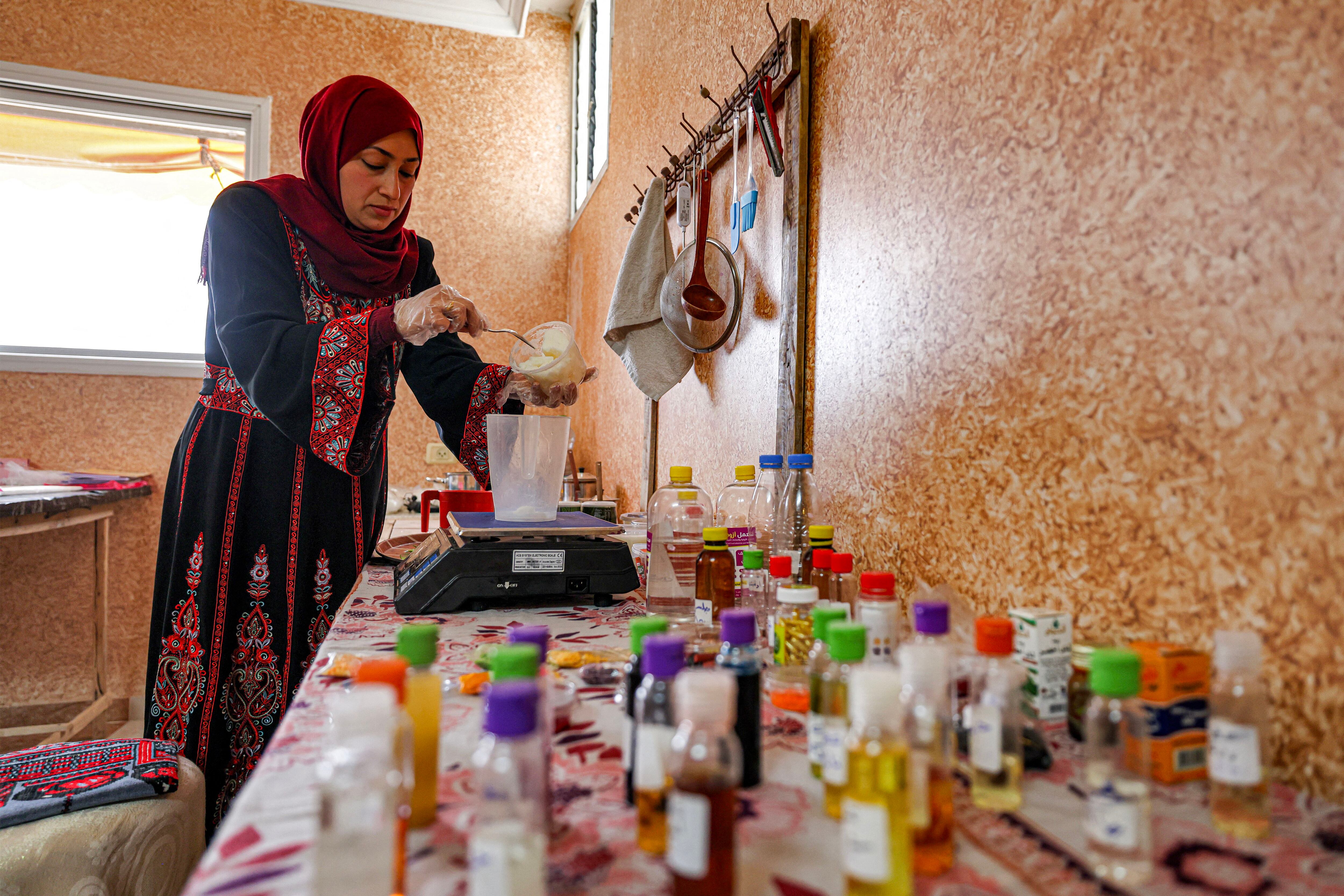 Alaa Badwan, una mujer palestina de 37 años, prepara jabón con aceite de aloe vera extraído en su casa en Deir al-Balah.