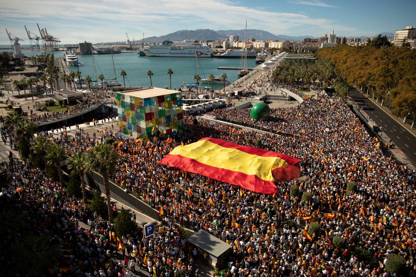 Los manifestantes marchan con una bandera gigante de España durante una protesta convocada por la oposición de derecha contra un proyecto de ley de amnistía para las personas involucradas en el fallido intento de independencia de Cataluña.