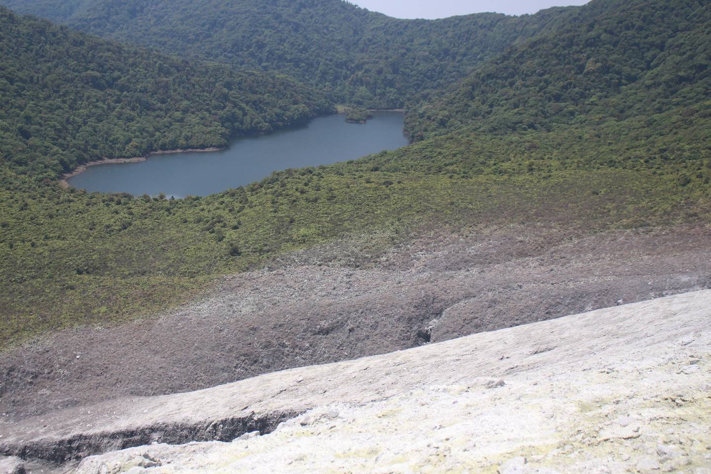 La  parte grisácea entre el cráter activo (parte inferior) y una laguna en el macizo (partre superior) corresponde a la vegetación quemada por los flujos piroclásticos generados en la erupción del 21 de abril. Foto: Geoffroy Avard/Ovsicori.