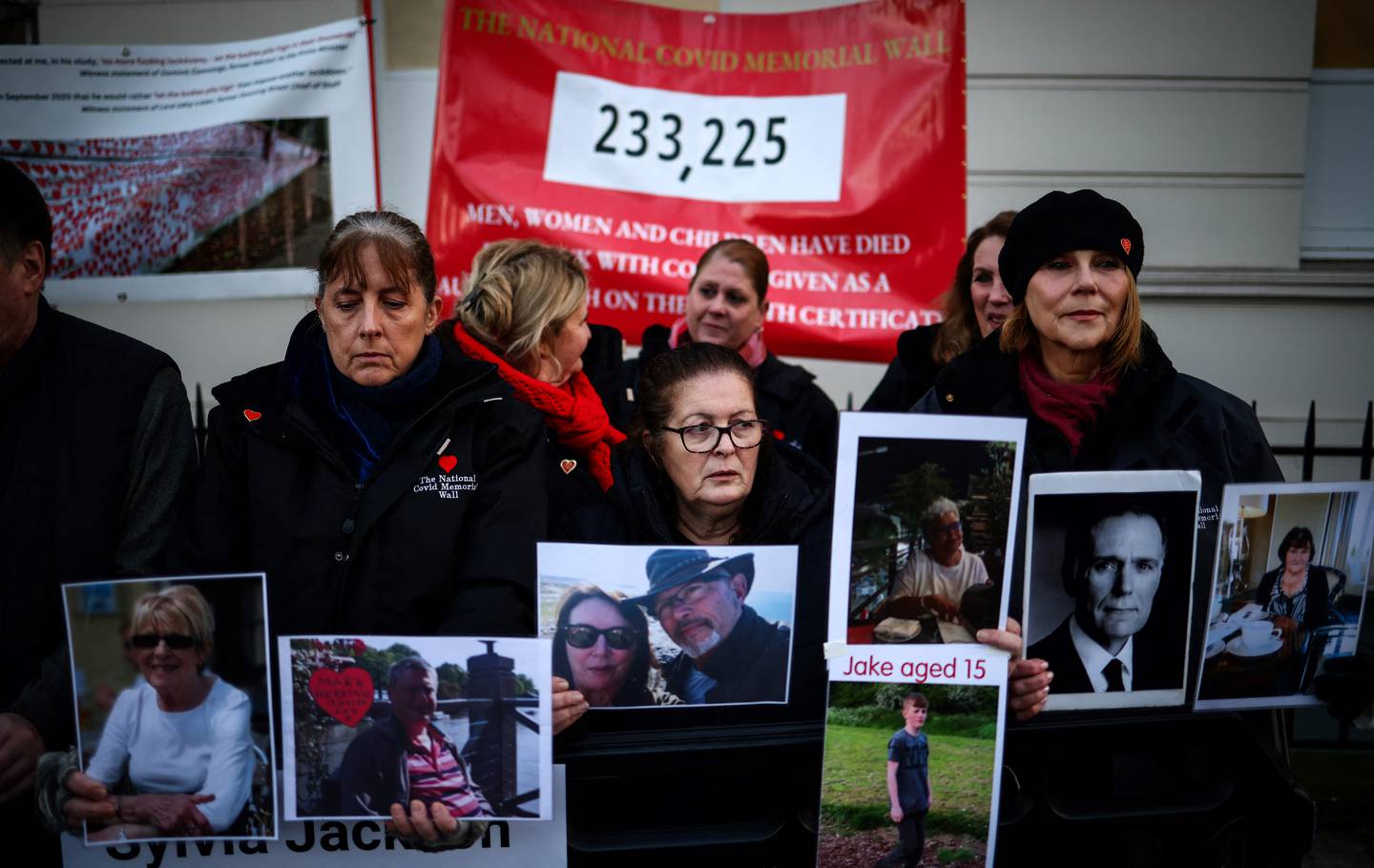 Manifestantes con pancartas y fotografías de víctimas de Covid-19 se reúnen frente a la entrada del edificio de investigación Covid-19 del Reino Unido en el oeste de Londres.