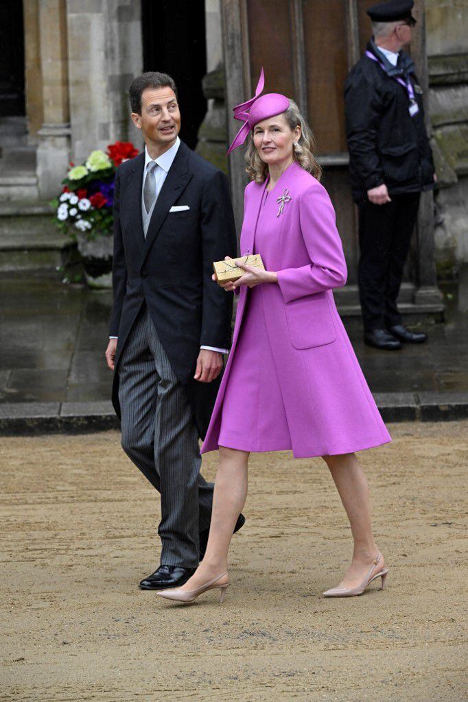 Alois y Sophie, príncipes herederos de Liechtenstein, optaron por looks similares. Sophie utilizó un vestido morado y un abrigo levita de corte 'new look', el cual acompañó con un híbrido de sombrero y un tocado. 