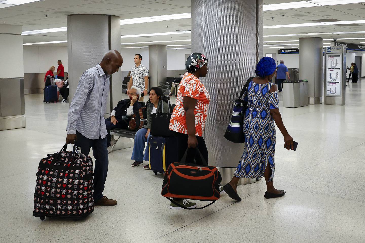 Los ciudadanos haitiano-estadounidenses parten después de llegar en un vuelo chárter desde Cap-Haitien al Aeropuerto Internacional de Miami.