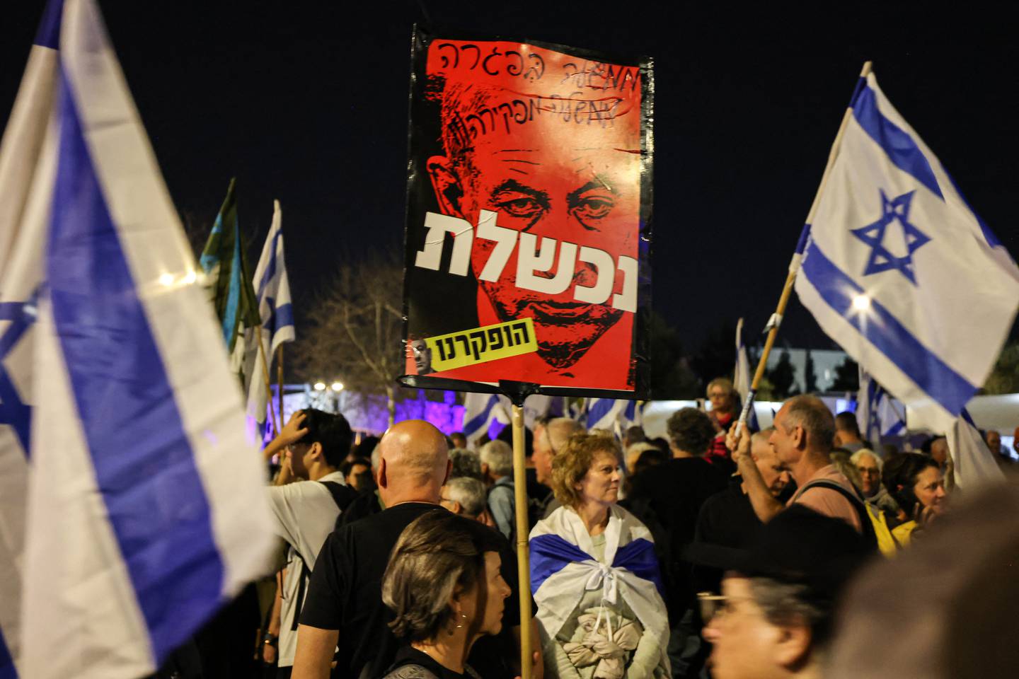 Los manifestantes sostienen carteles durante una protesta contra el gobierno israelí y para exigir la liberación segura de los rehenes retenidos por el movimiento palestino Hamas en la Franja de Gaza.