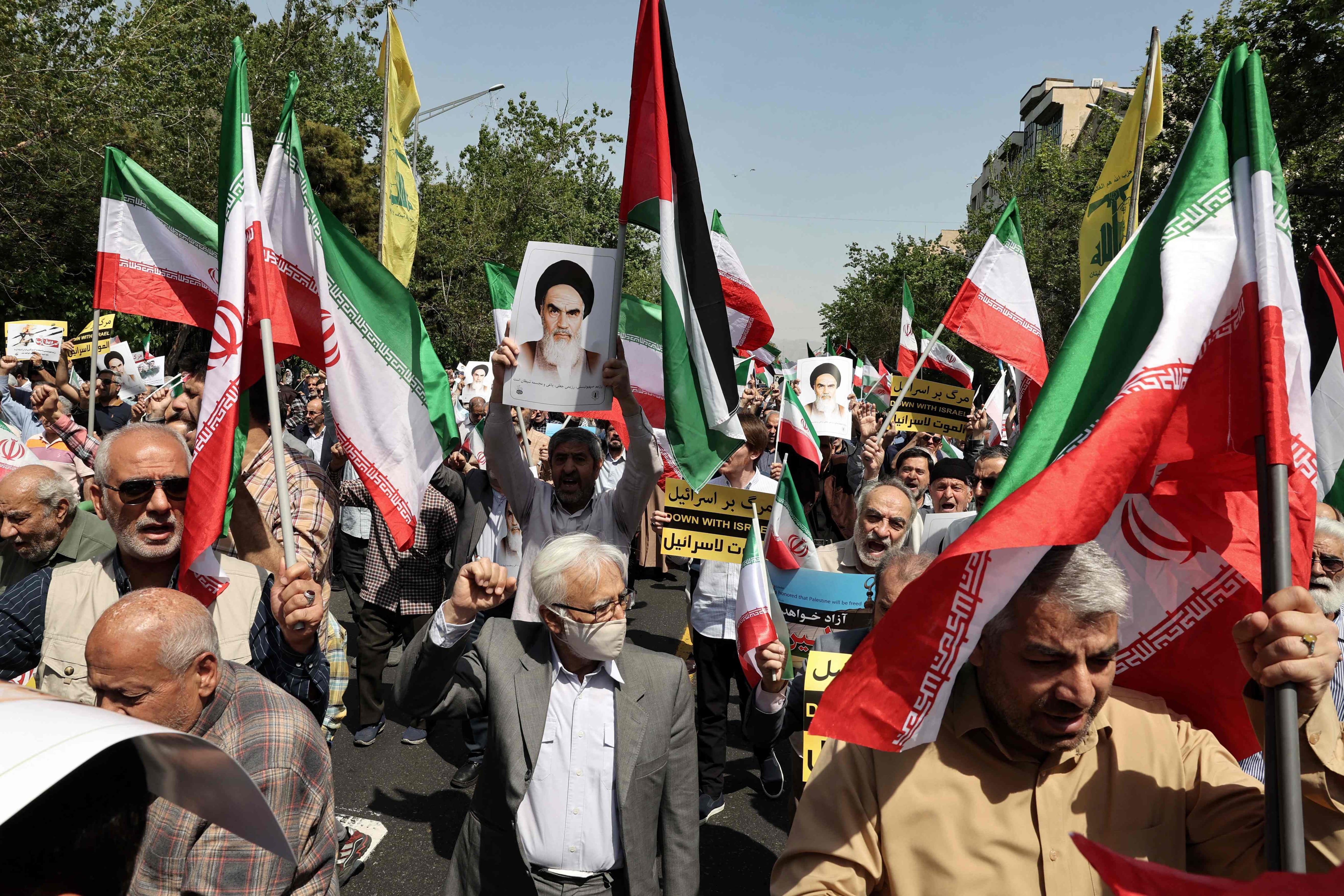 Los iraníes agitan las banderas de Palestina e Irán durante una manifestación antiisraelí después de la oración del mediodía del viernes en Teherán. Los líderes mundiales pidieron calma el 19 de abril después de que las represalias israelíes contra Irán se sumaran a meses de tensas consecuencias de la guerra en Gaza, y los medios estatales iraníes informaron de explosiones en la provincia central de Isfahán. (Foto de Atta KENARE / AFP)