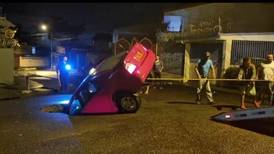 Taxi se hunde en enorme hueco sobre carretera en Alajuela