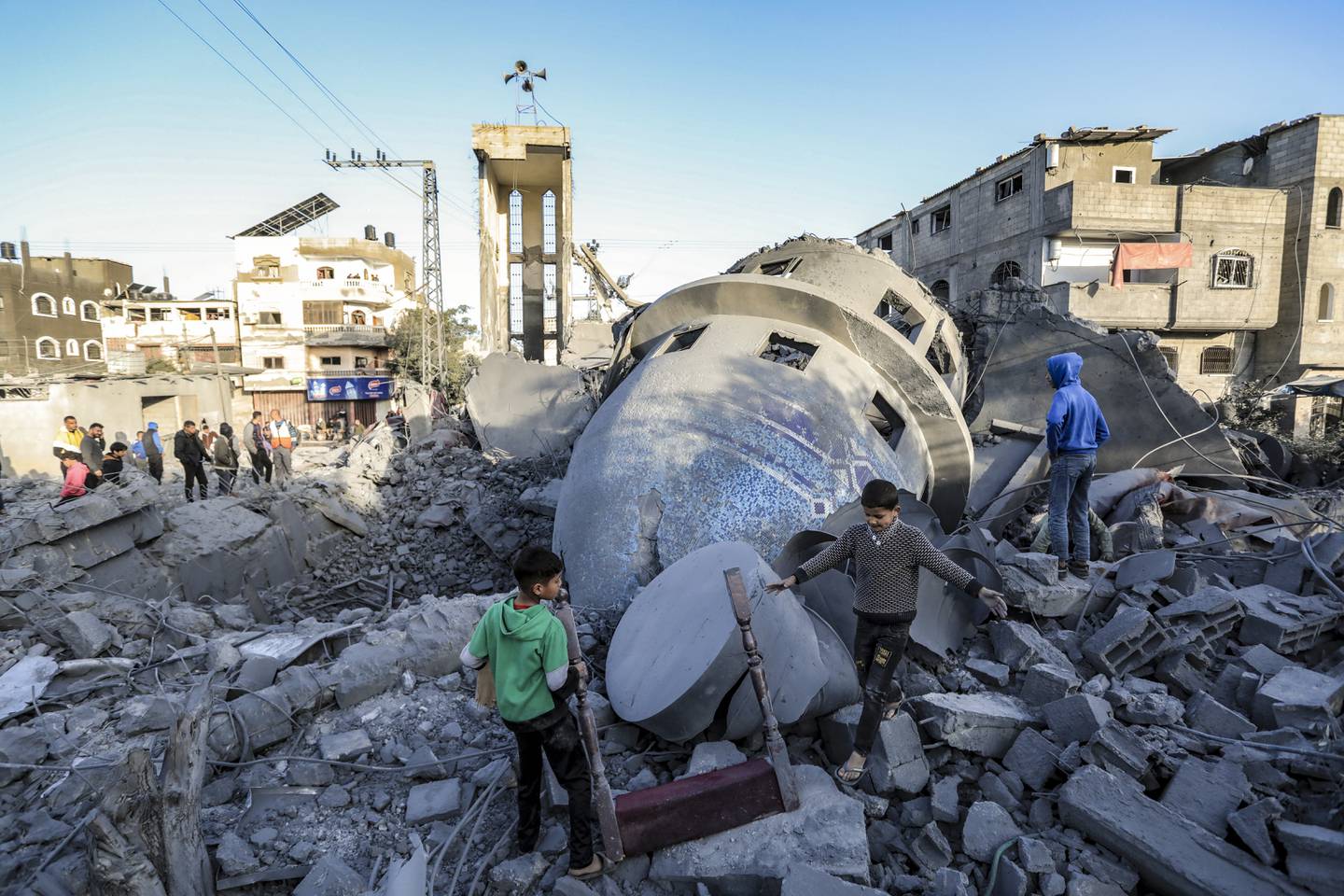 Los niños buscan artículos recuperables entre los escombros de la mezquita de Al-Bukhari destruida en los ataques israelíes en Deir al-Balah, en el centro de Gaza, mientras continúan las batallas entre Israel y el grupo militante palestino Hamas. (Foto de AFP)