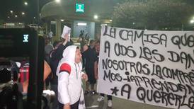 Aficionados de Alajuelense reciben al equipo con reproches, mantas y monedas