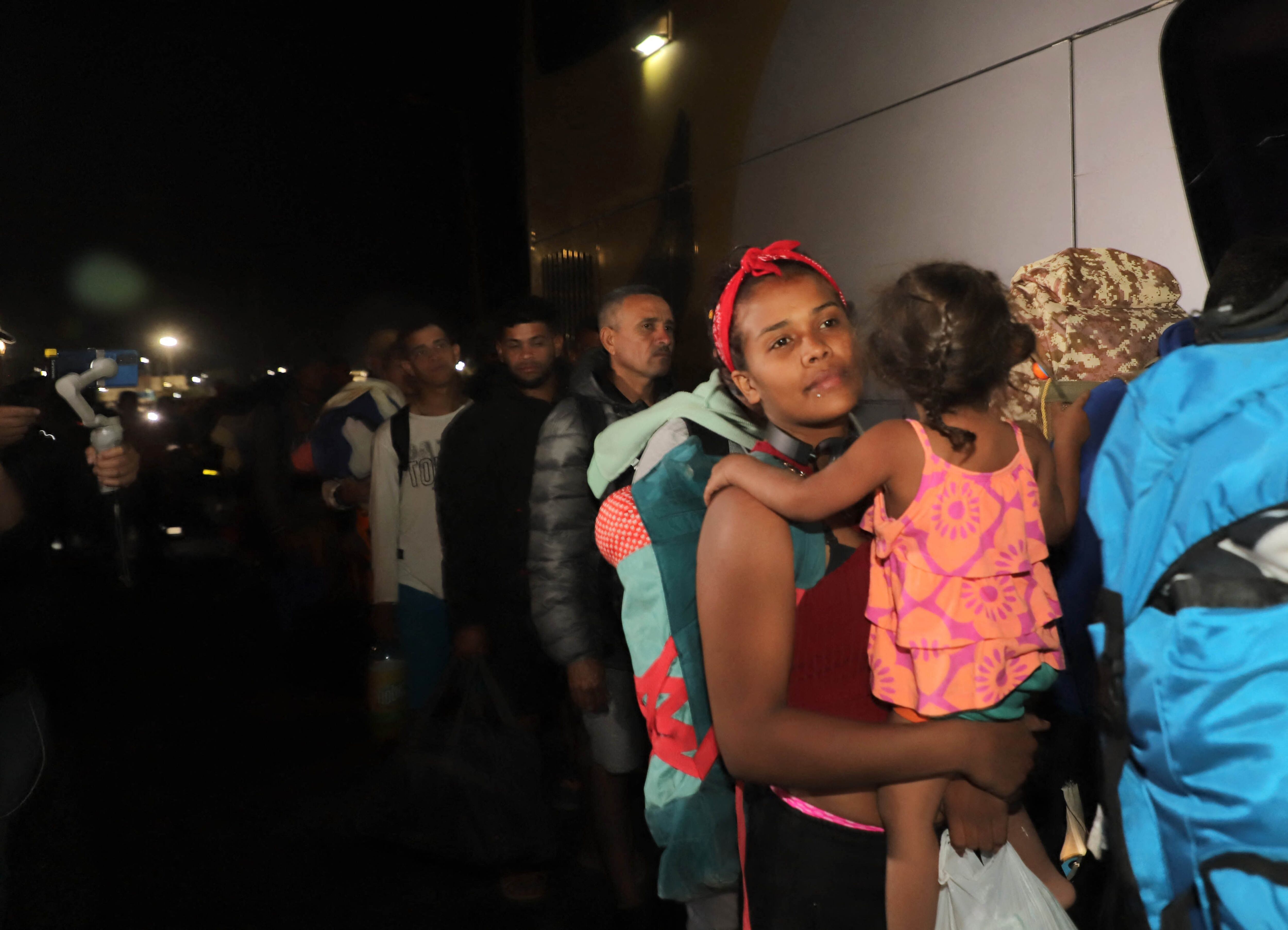 Migrantes venezolanos esperan para abordar un bus que los traslade a un refugio en Chile el 5 de mayo.