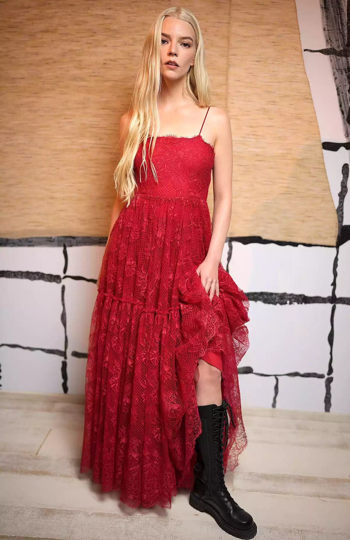 La actriz Anya Taylor-Joy lució un vestido de encaje rojo combinado con botas de moto hasta la rodilla.