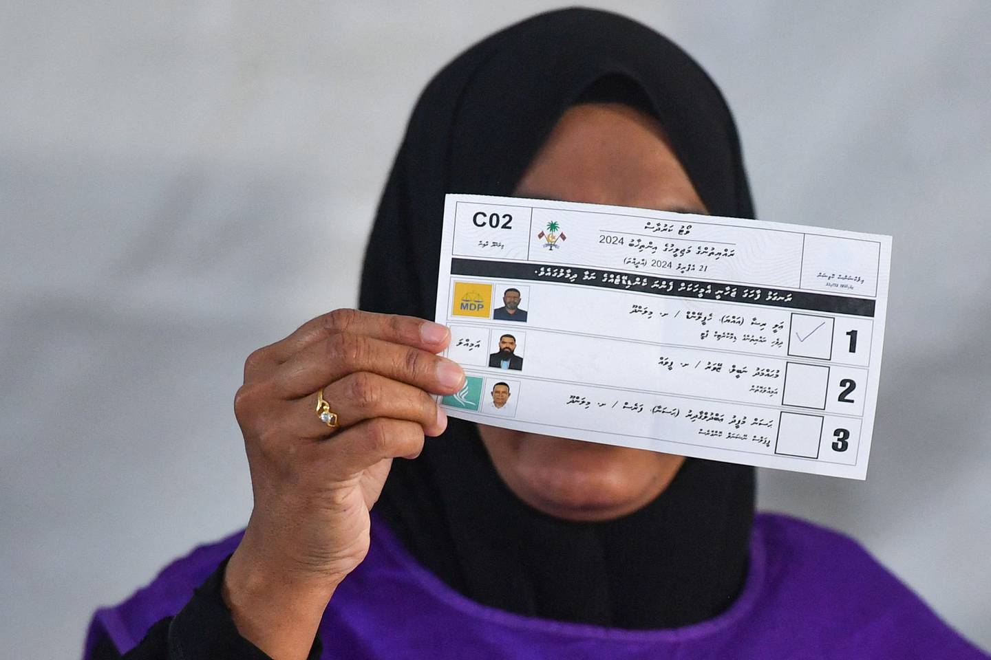 Una oficial muestra las papeletas en las votaciones legislativas en las Maldivas. (Photo by Mohamed Afrah / AFP)