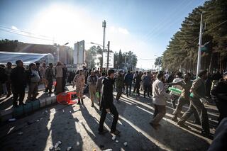 La gente se dispersa cerca del lugar donde dos explosiones en rápida sucesión golpearon a una multitud que conmemoraba el aniversario del asesinato en 2020 del general de la Guardia Qasem Soleimani, cerca de la mezquita Saheb al-Zaman en la ciudad de Kerman