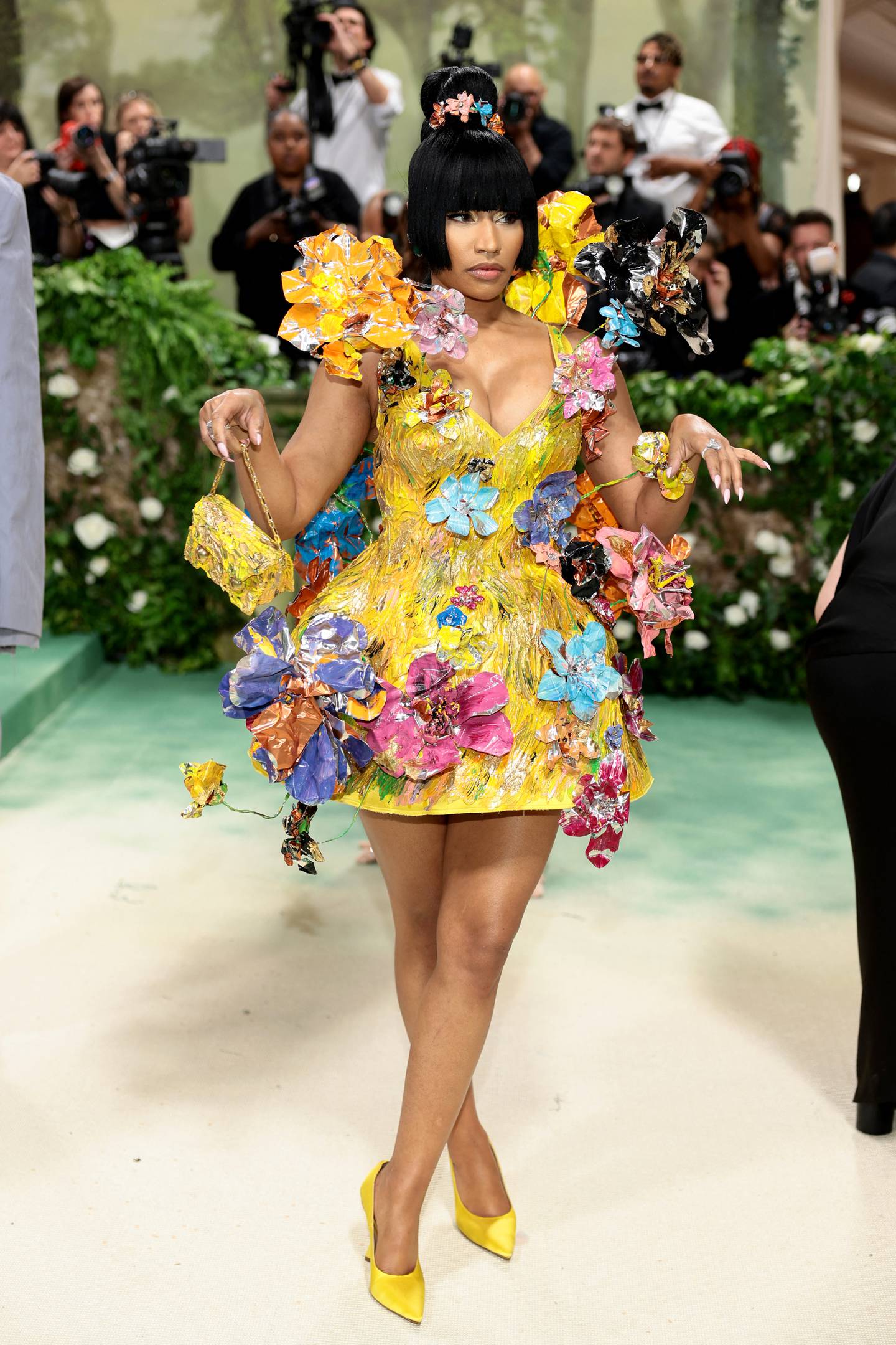 La cantante y rapera estadounidense, Nicki Minaj, fue elogiada en redes por utilizar un vestido amarillo cubierto de flores metálicas en 3D. Vogue describió su atuendo como una "escultura floral".