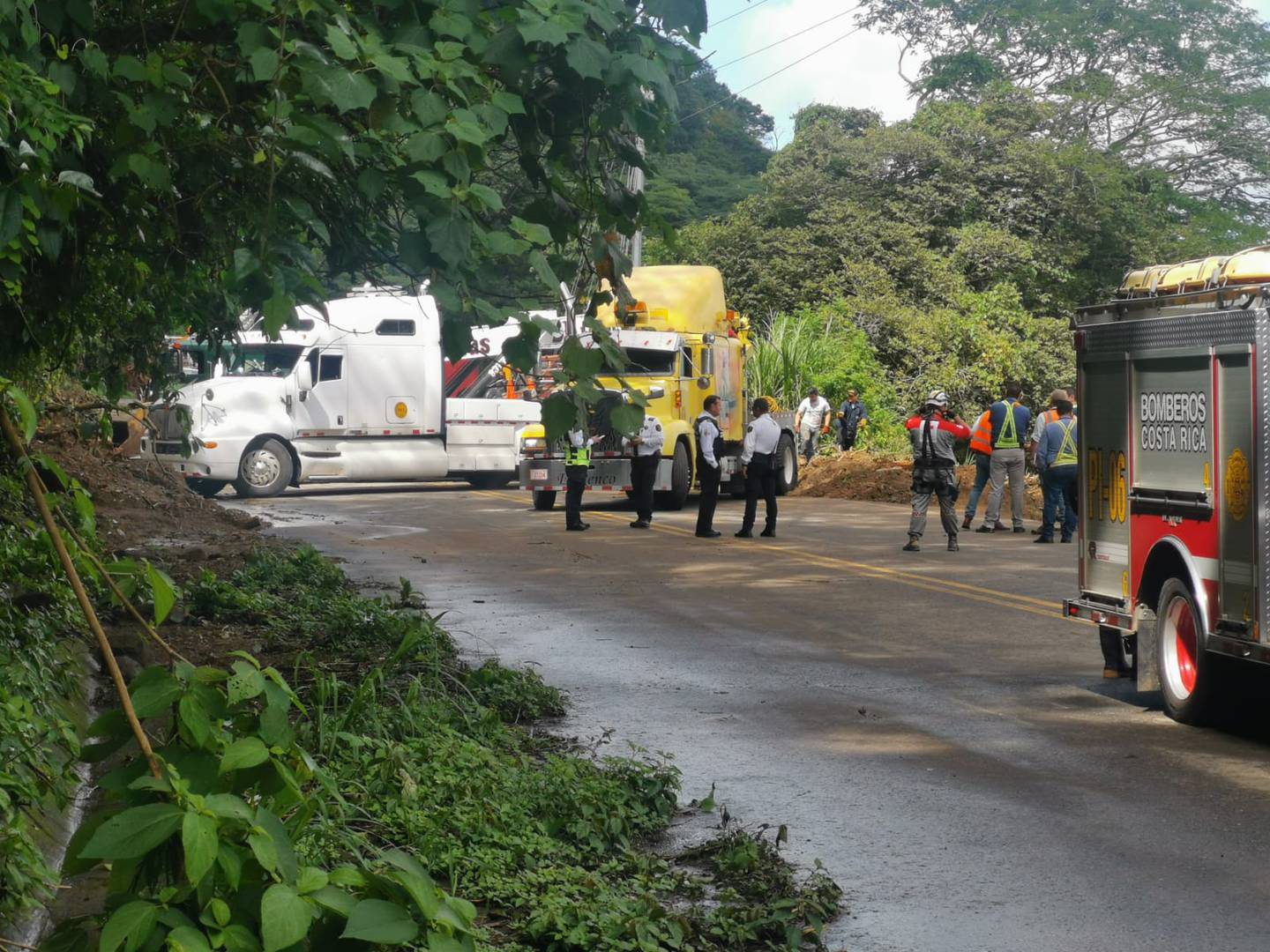 Socorristas, Policía de Tránsito, grueros y funcionarios del MOPT son parte de quienes están en Cambronero a la espera de sacar el bus arrastrado por el deslizamiento el sábado. Foto: Cortesía.