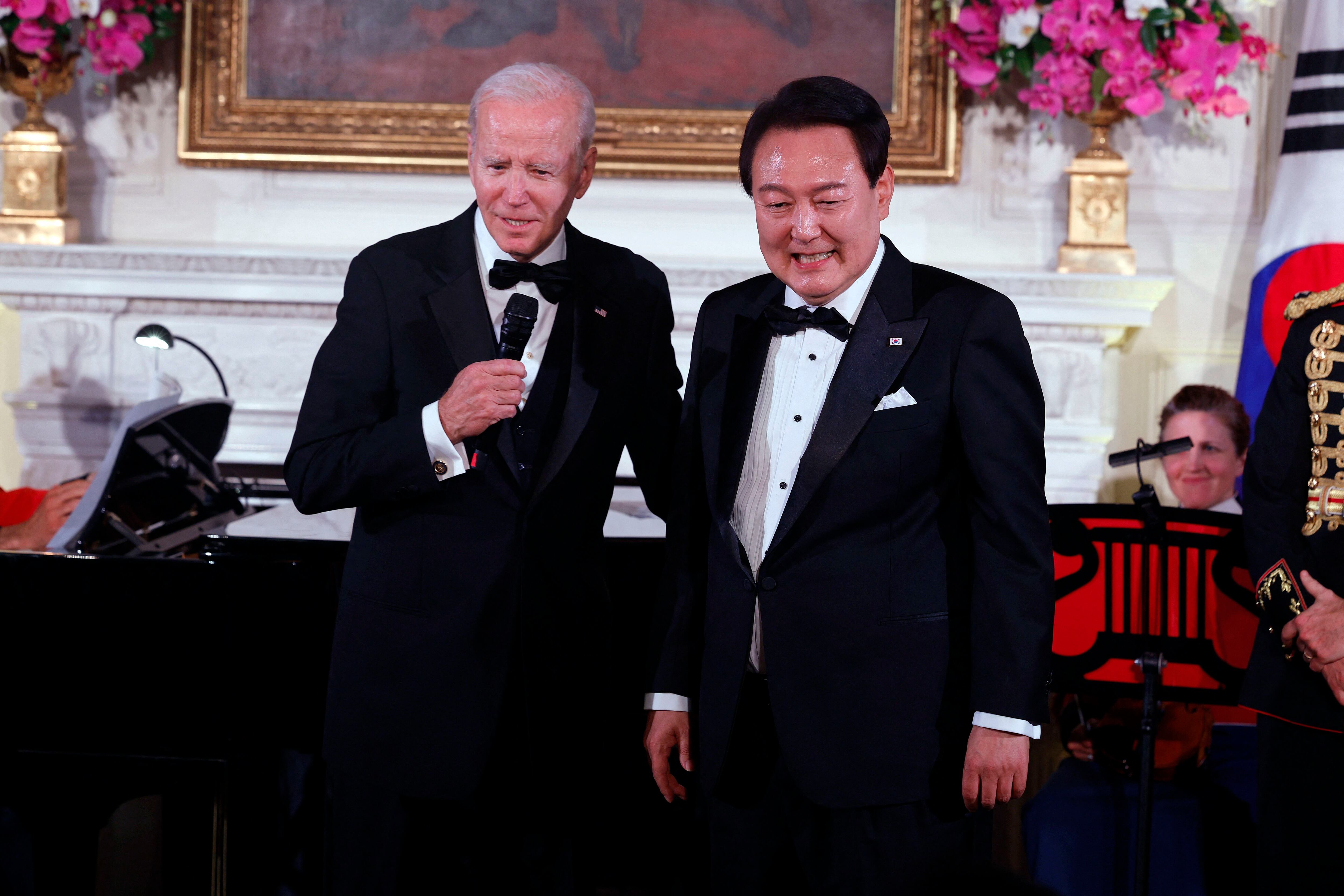 El presidente Joe Biden (izquierda) y el presidente de Corea del Sur, Yoon Suk-yeol, hablan durante una cena de estado en la Casa Blanca. 