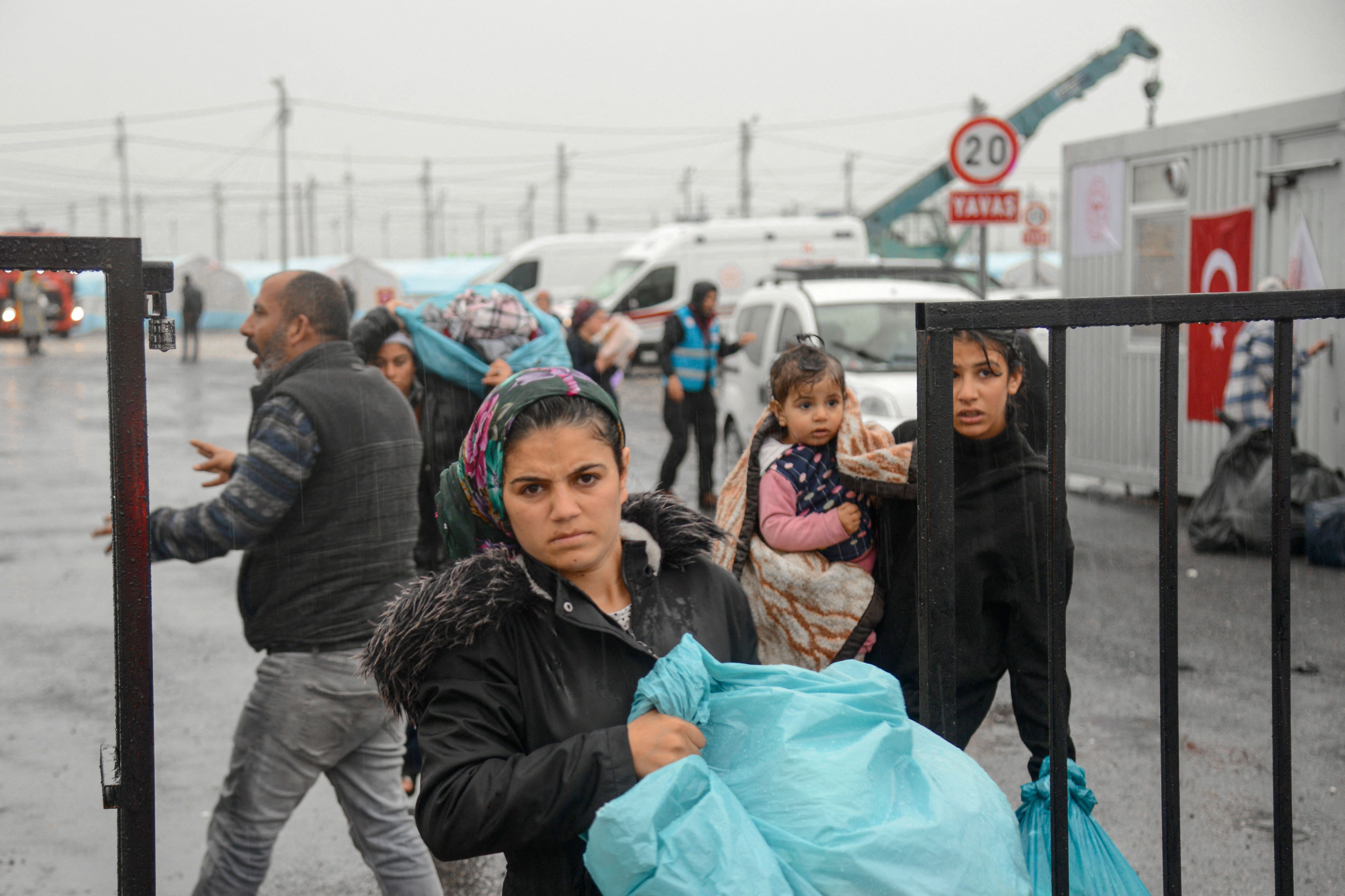 Los sobrevivientes de los terremotos abandonan el campo de refugiados cuando las fuertes lluvias azotaron la región, en Diyarbakir. FOTO: