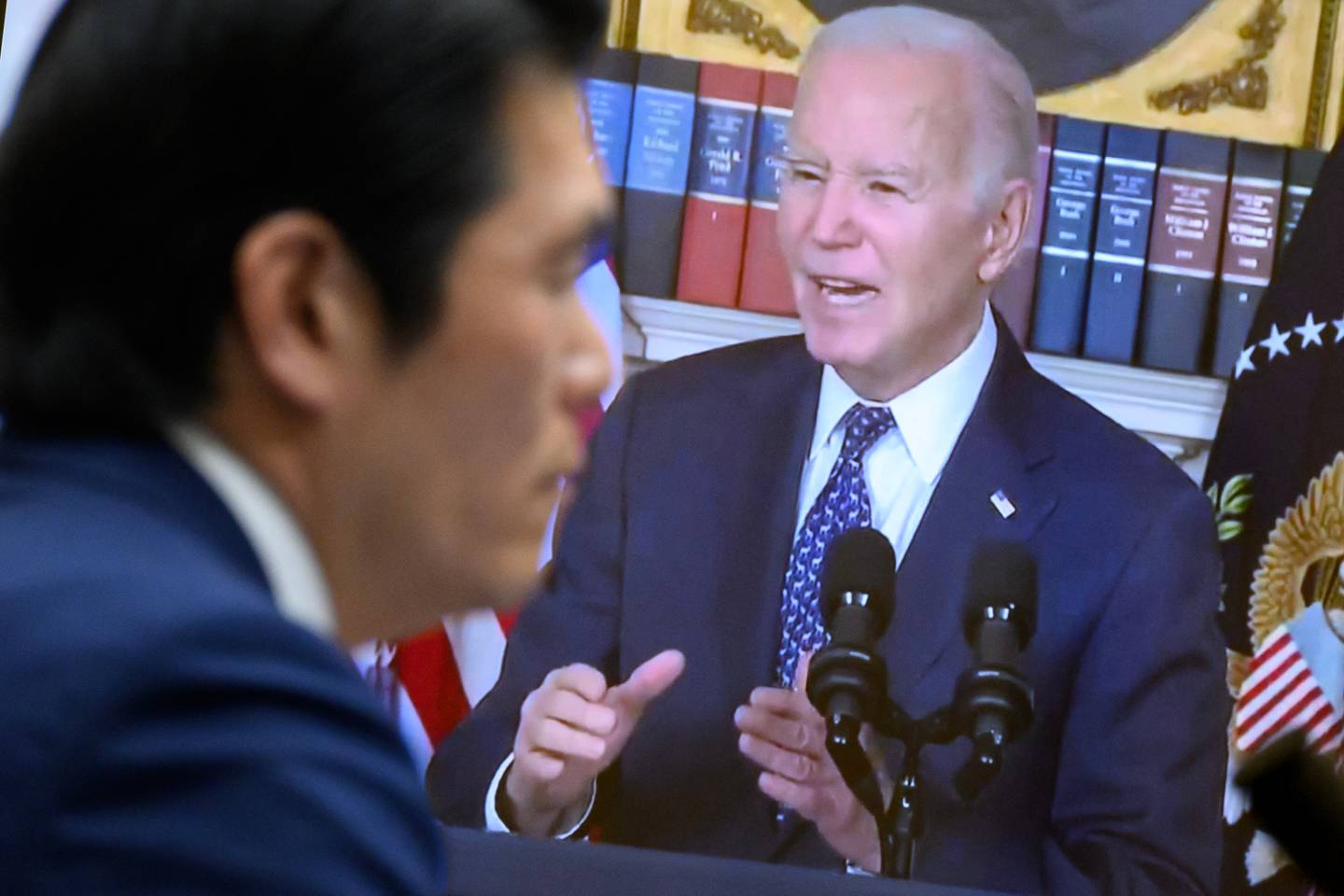 En un monitor se ve una imagen del presidente estadounidense Joe Biden hablando en una conferencia de prensa en respuesta al informe del fiscal especial mientras el fiscal especial Robert Hur.
