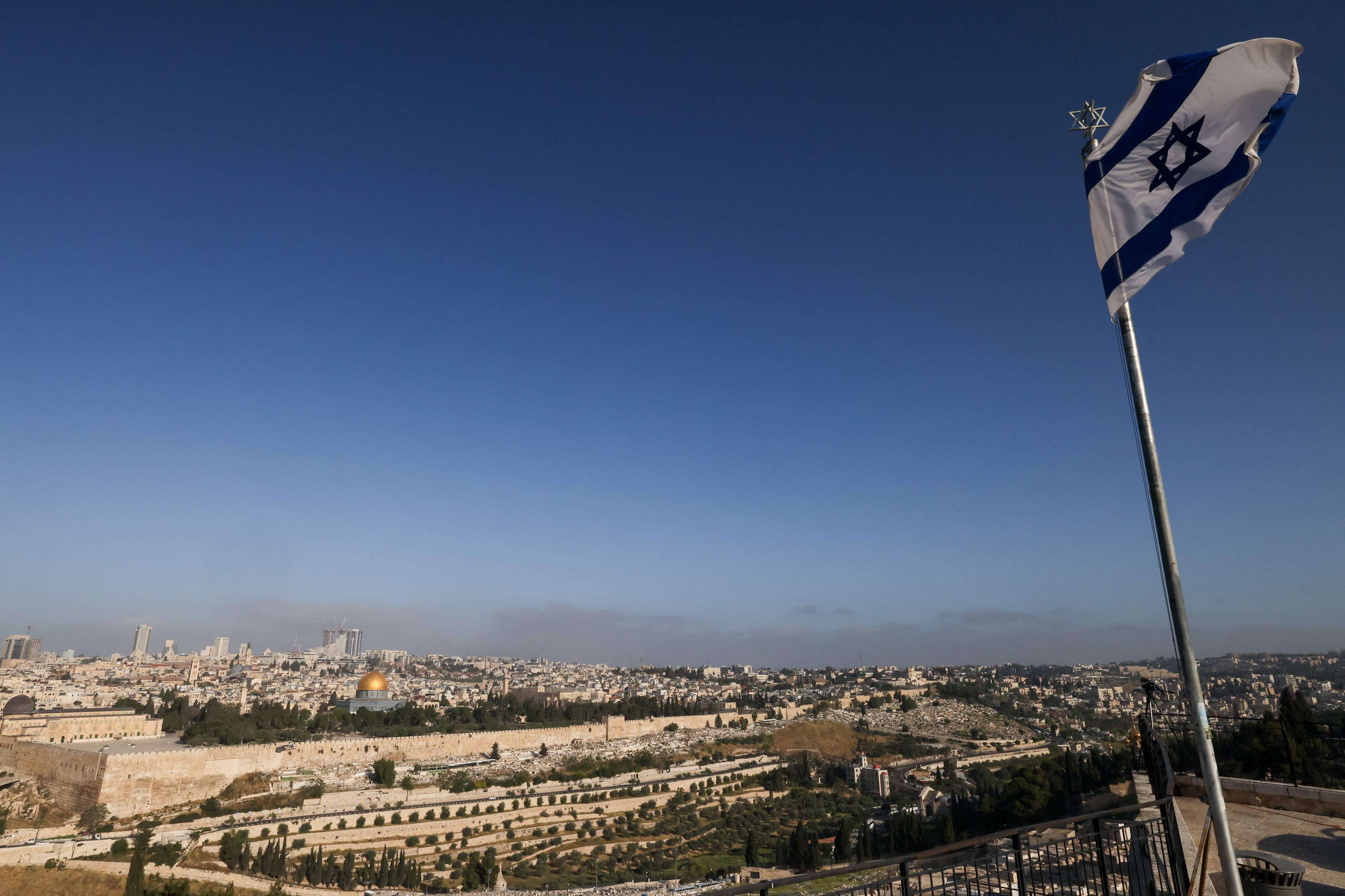 Una bandera israelí ondea en el Monte de los Olivos con vistas al recinto de la mezquita de Al Aqsa y al horizonte de la ciudad en Jerusalén. Los medios estadounidenses citaron a funcionarios que dijeron que Israel había llevado a cabo ataques de represalia contra su archirrival Irán, mientras que los medios estatales de Irán informaron explosiones en la provincia central de Isfahán el 19 de abril. (Foto de AHMAD GHARABLI / AFP)