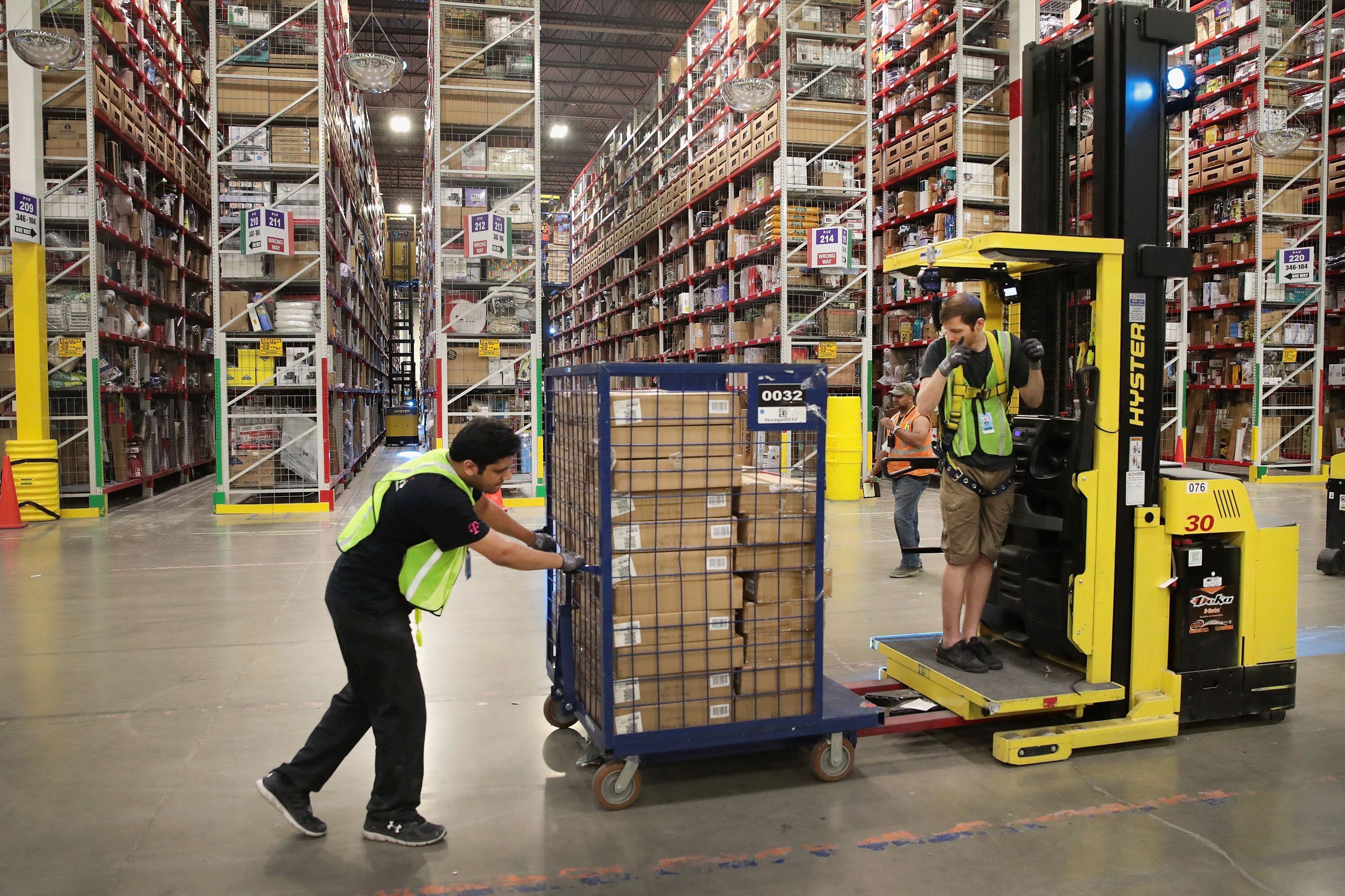 Los trabajadores empacan y envían los pedidos de los clientes en el centro logístico de Amazon de 750,000 pies cuadrados en Romeoville, Illinois. Archivo: