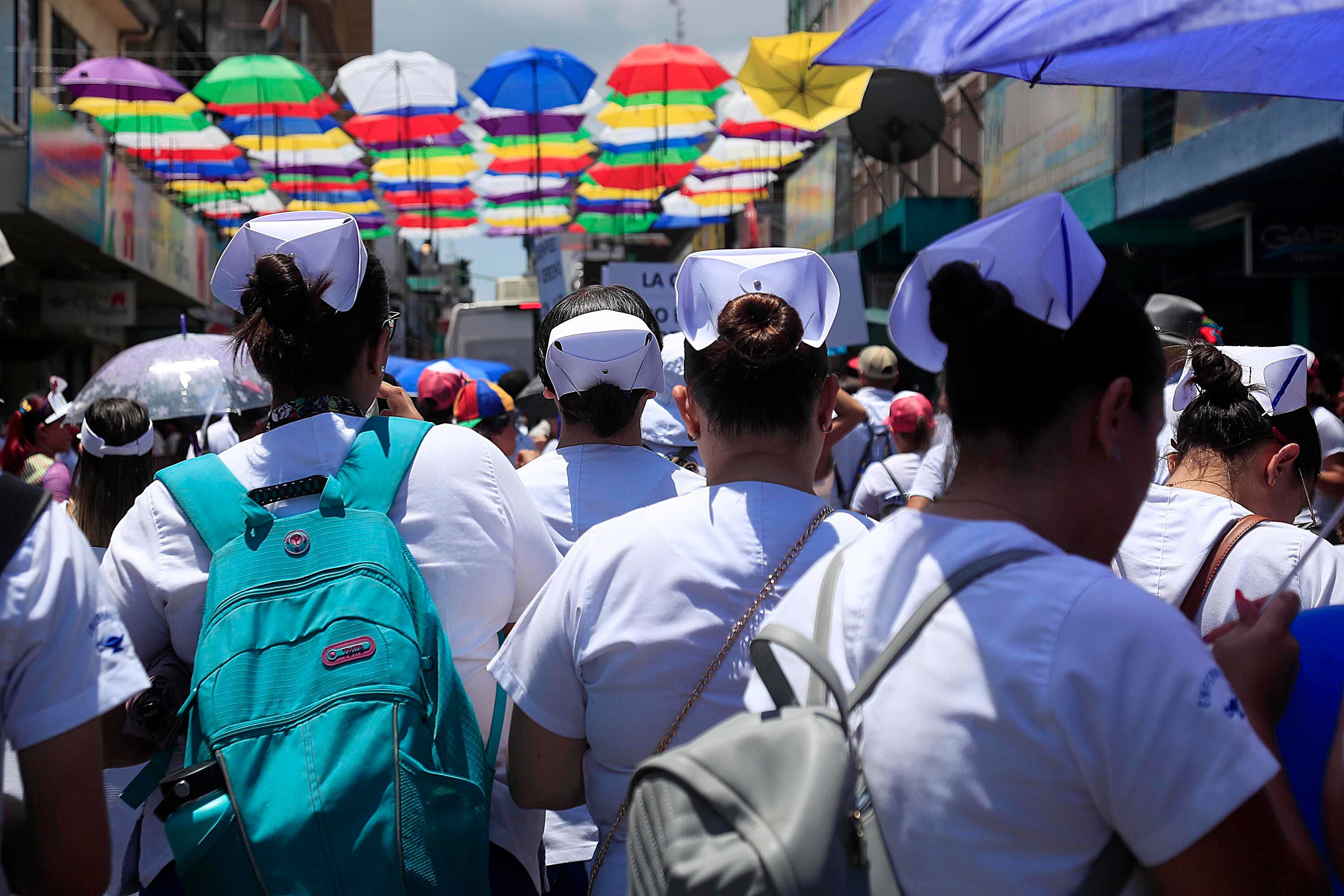 Escoltados por sombrillas multicolores, decenas de profesionales de Enfermería lucieron este viernes sus cofias en San José. Ellos recordaron a los transeúntes la importancia de su trabajo en los servicios de salud. Foto:
