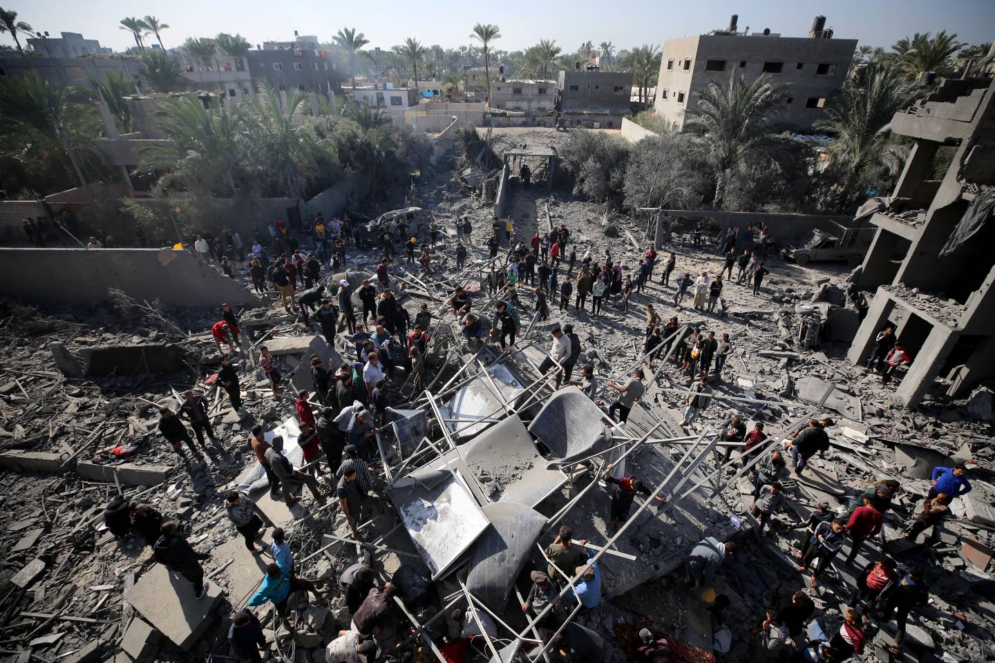Los palestinos buscan sobrevivientes entre los escombros de los edificios después de los ataques israelíes contra el campo de refugiados de al-Maghazi.